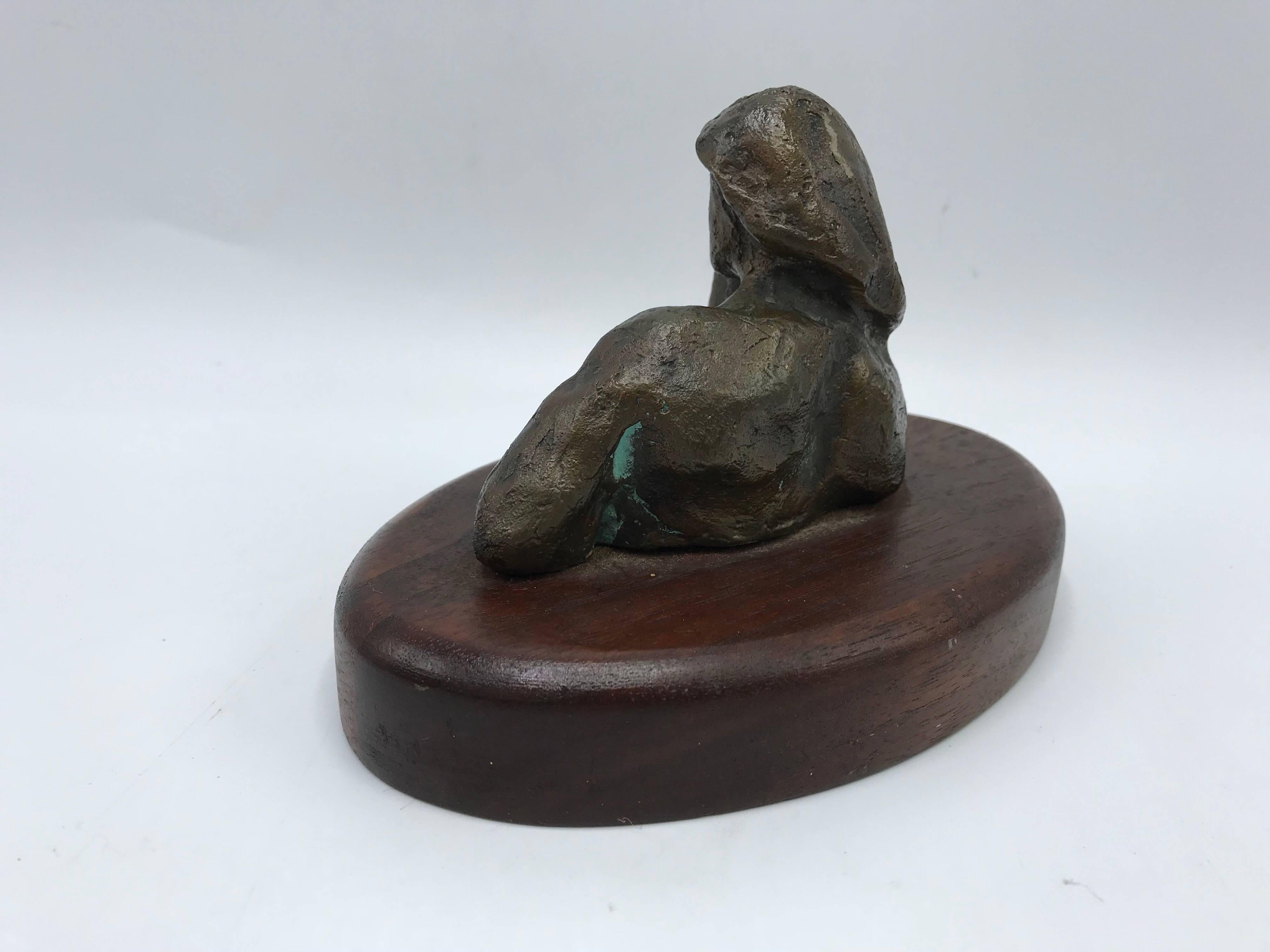 Listed is midcentury, 1970s bronze Brutalist nude female figure, reclined on a walnut wooden base. Unsigned.