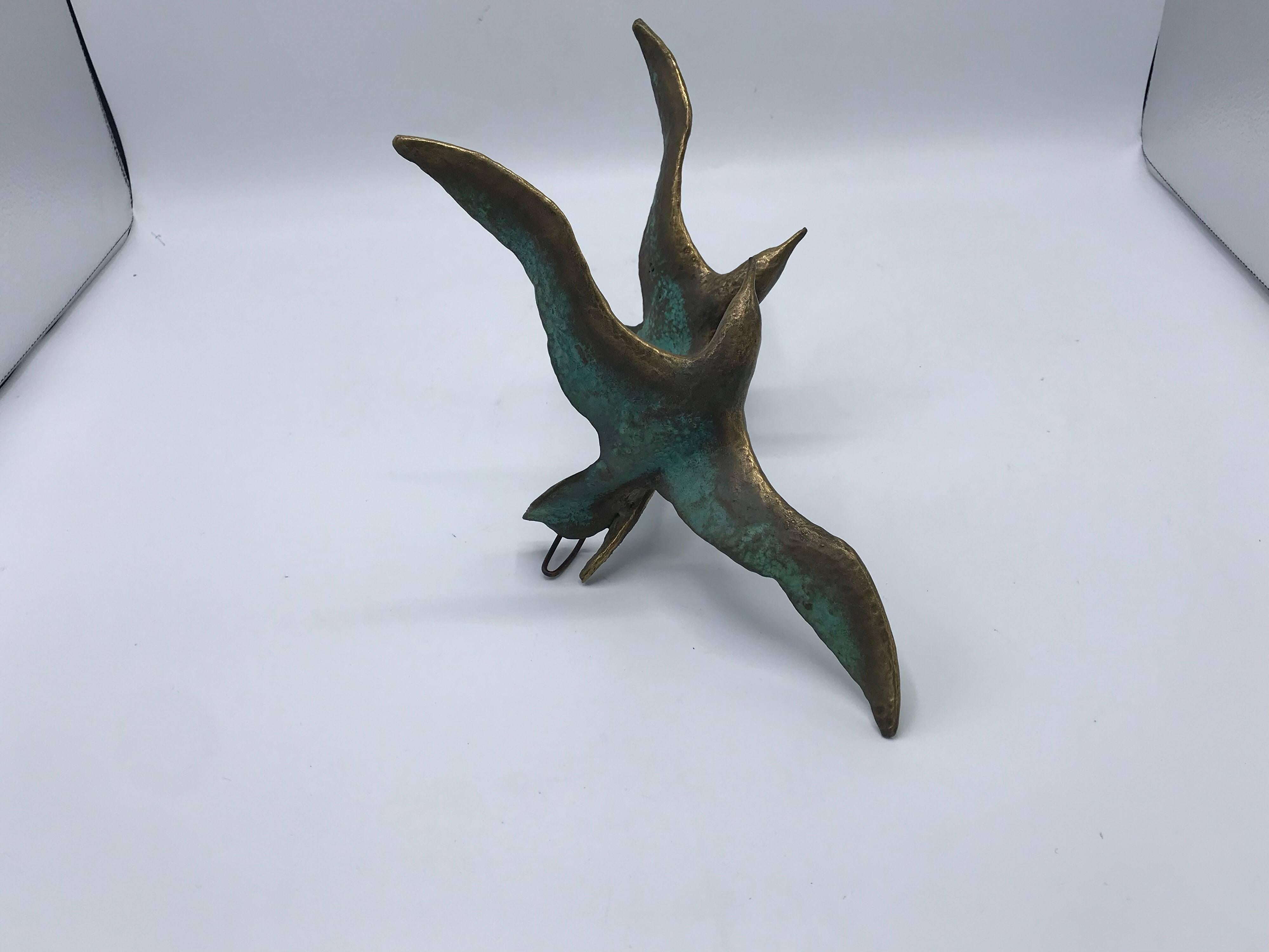 Listed is a beautiful and modern, 1970s modern bronze birds in flight wall sculpture. Easily hangs with wall hook on backside.