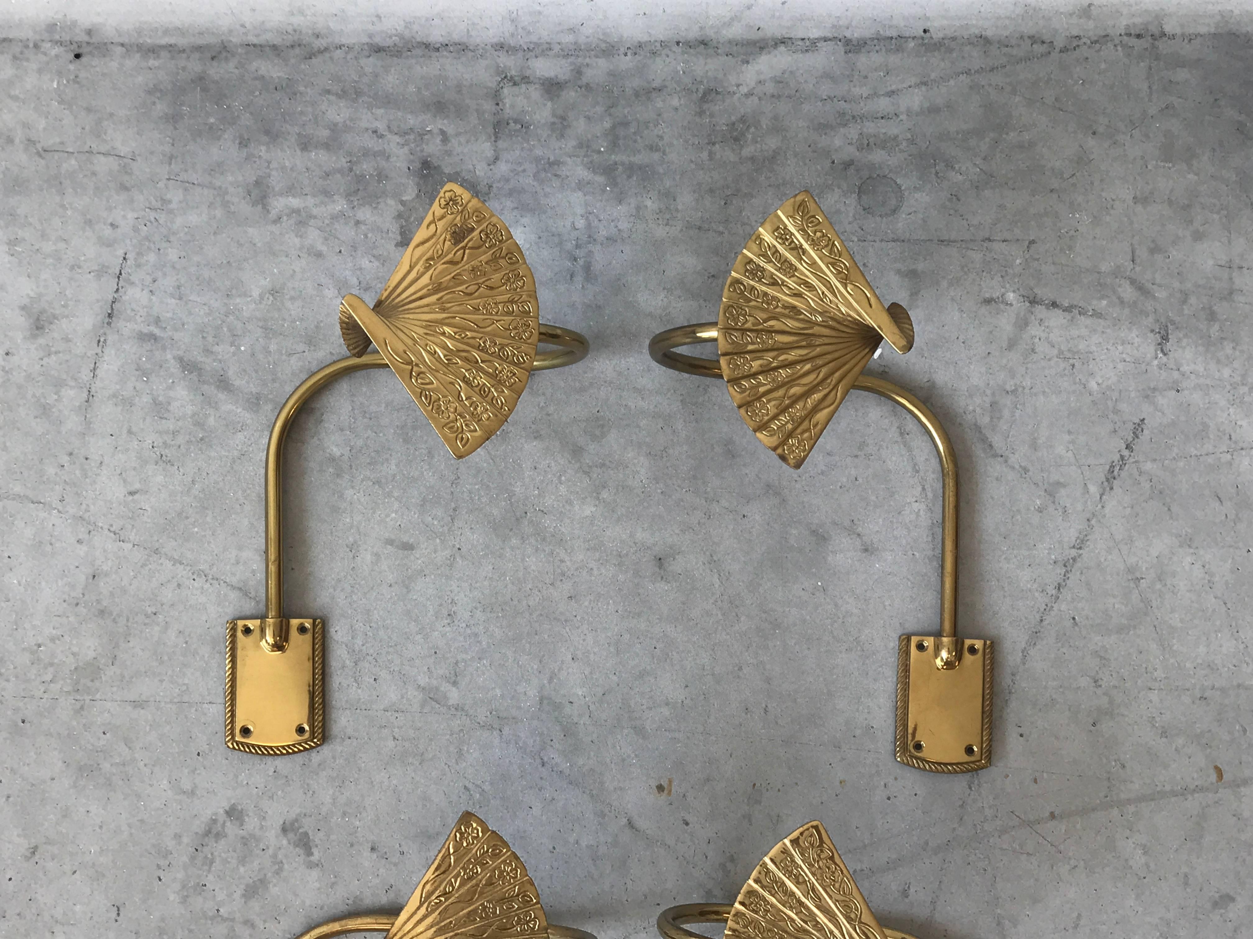 Offered is a gorgeous, pair of 1960s brass chinoiserie Asian fan motif curtain tie backs. Three pairs available. 

Please inquire if interested in multiple pairs. 

Each fan is 3.75
