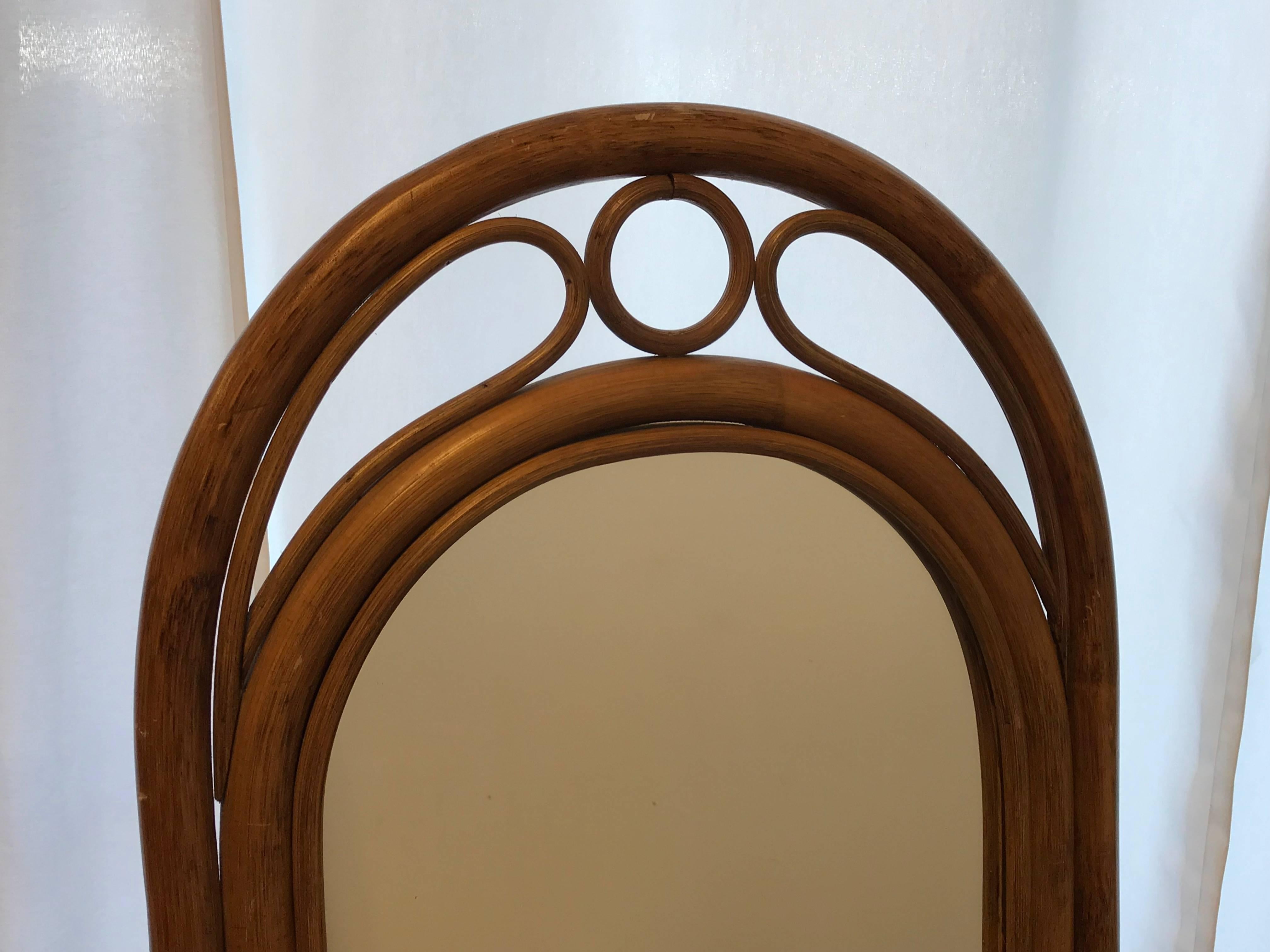 Offered is a fabulous, chinoiserie-chic 1970s bamboo and rattan floor mirror. Stand can fold up for mirror to lean against a wall or hanging.