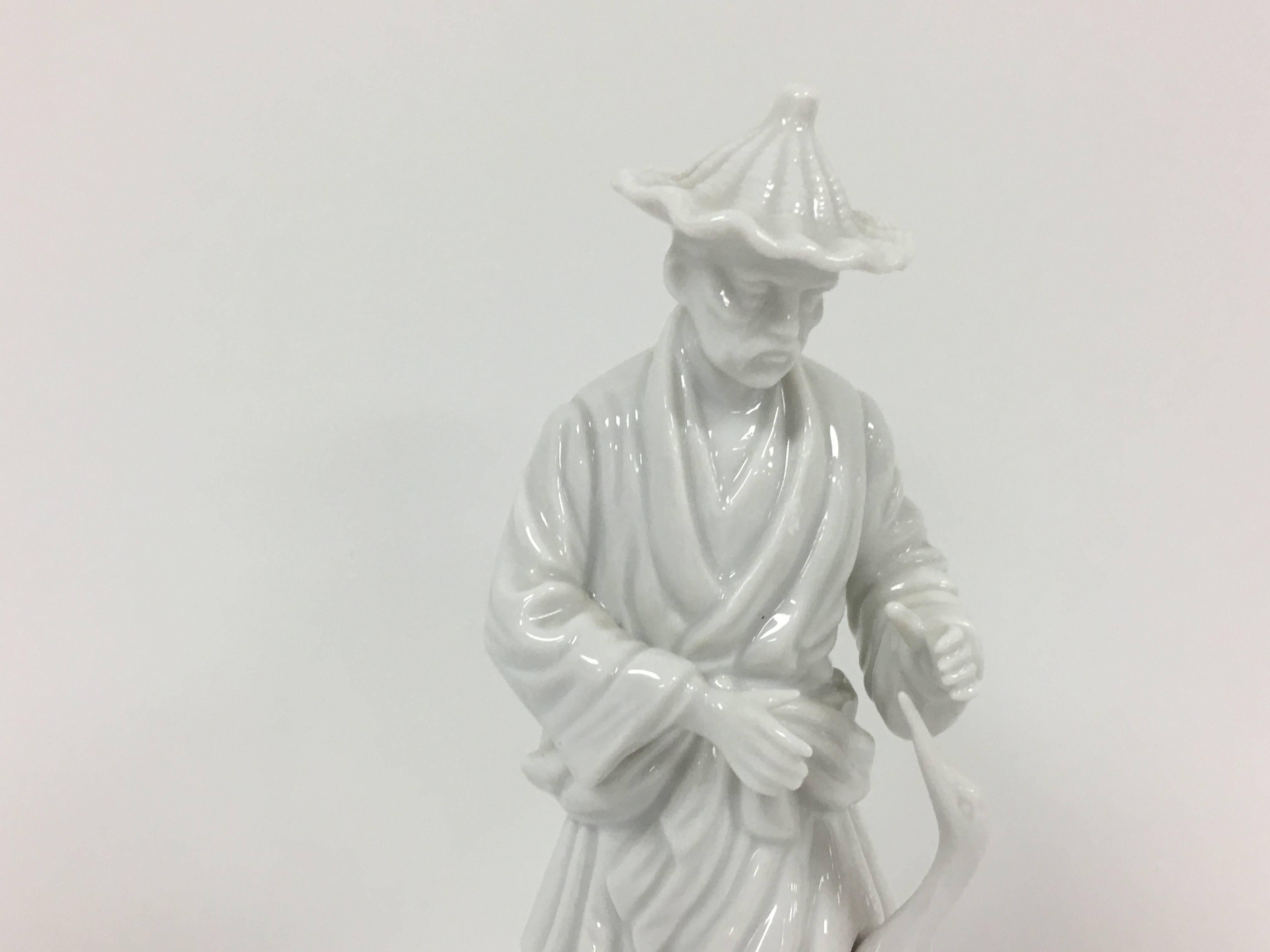 Listed is a stunning, Fitz and Floyd Blanc de Chine Asian farmer. He is standing beside a pelican.