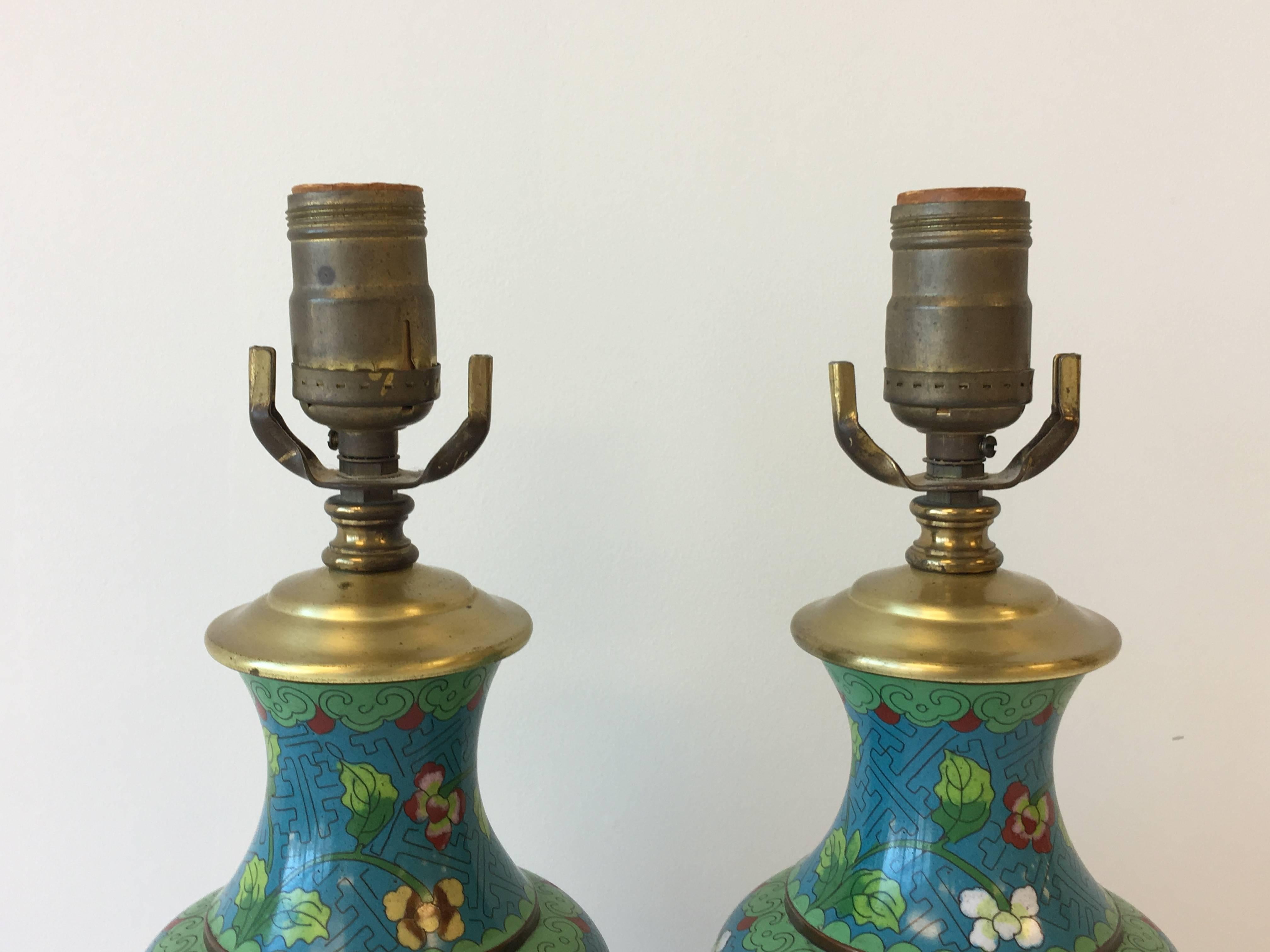 An elegant pair of 19th century cloisonné vases, converted into electrical lamps. A rich blue with floral motif and brass hardware.