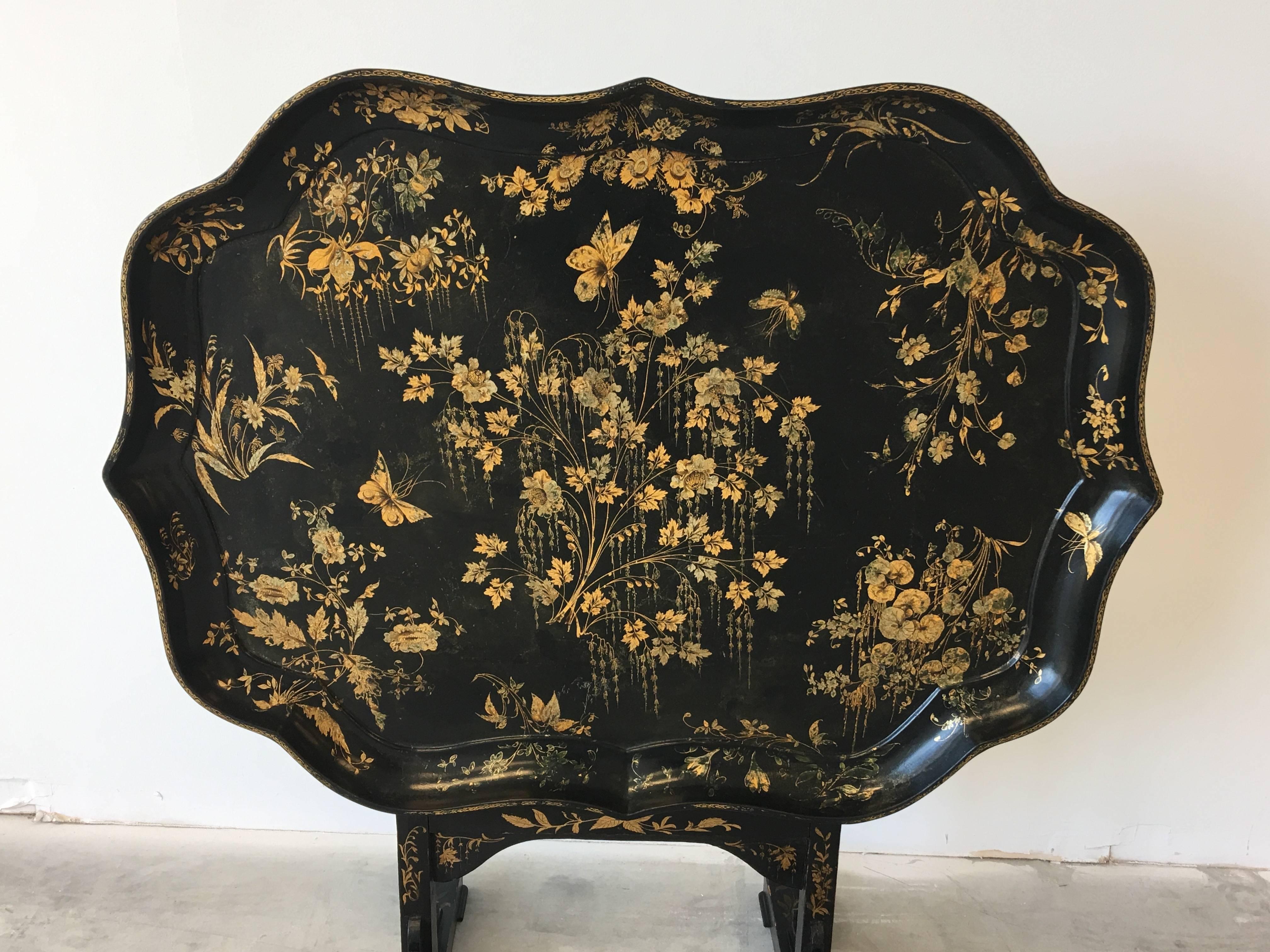 A fine, Japanned chinoiserie tilt-top table, decorated in gold and black with a floral design. Locking mechanism is excellent condition.