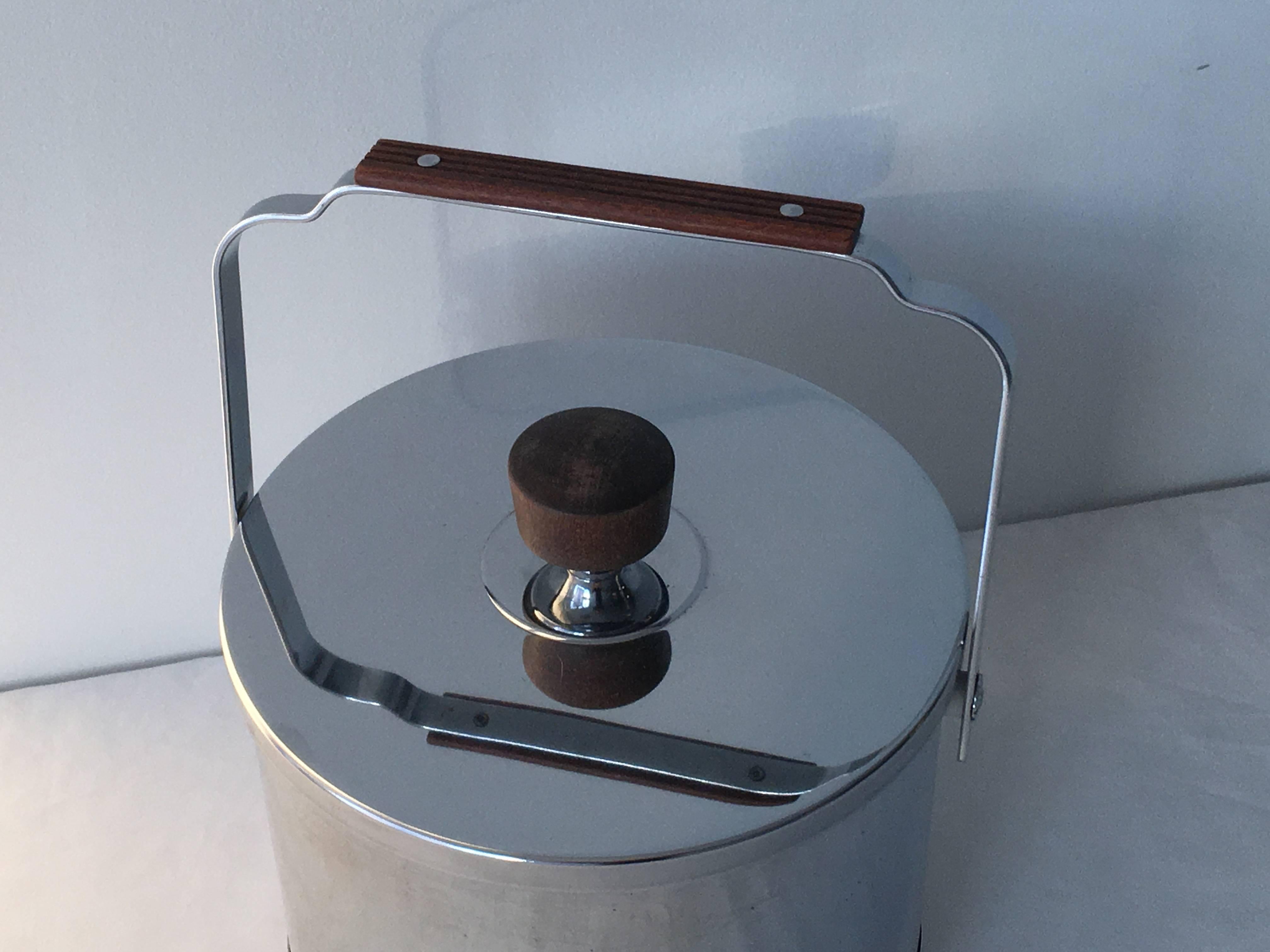 Sophisticated and sleek, Mid-Century Modern chrome ice bucket with teak handles.