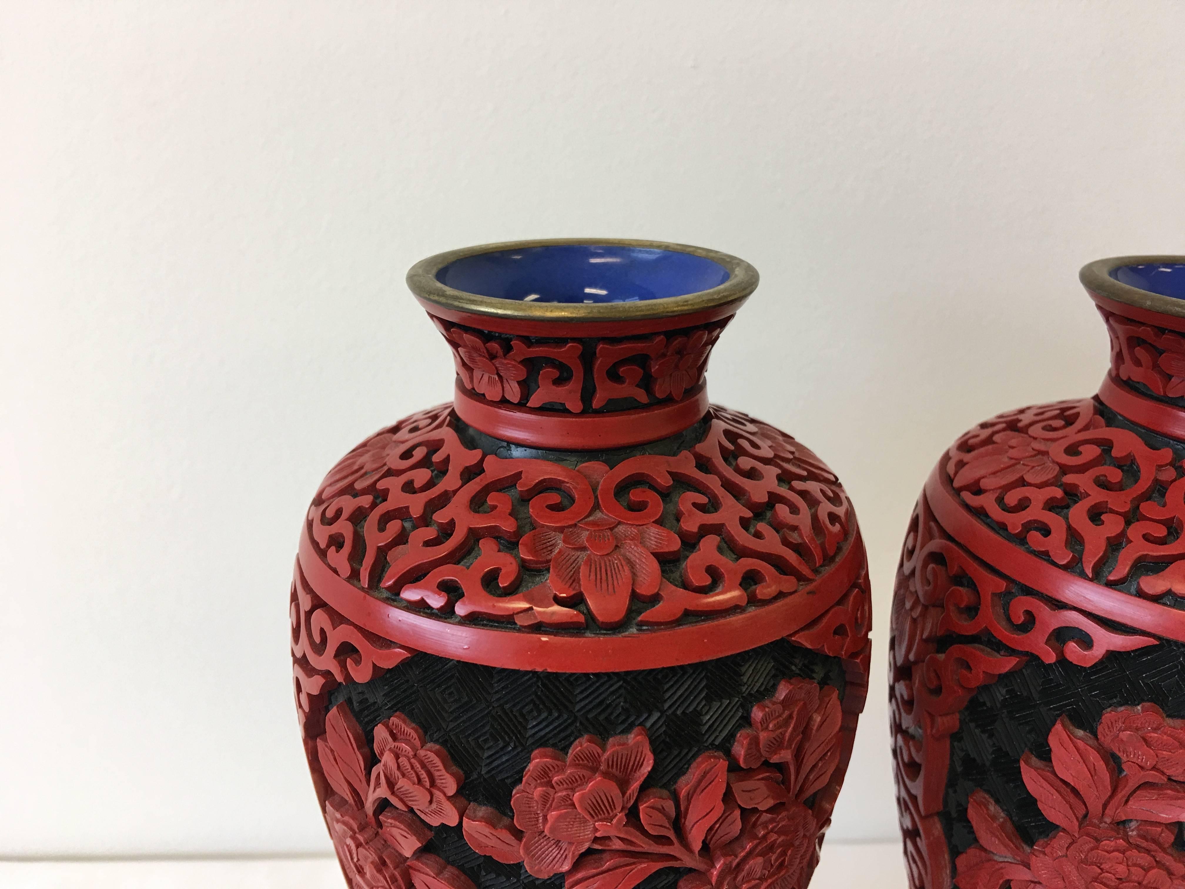 Offered is an elegant pair of 19th century, red Chinese cinnabar cloisonné vases on ornate wood stands.