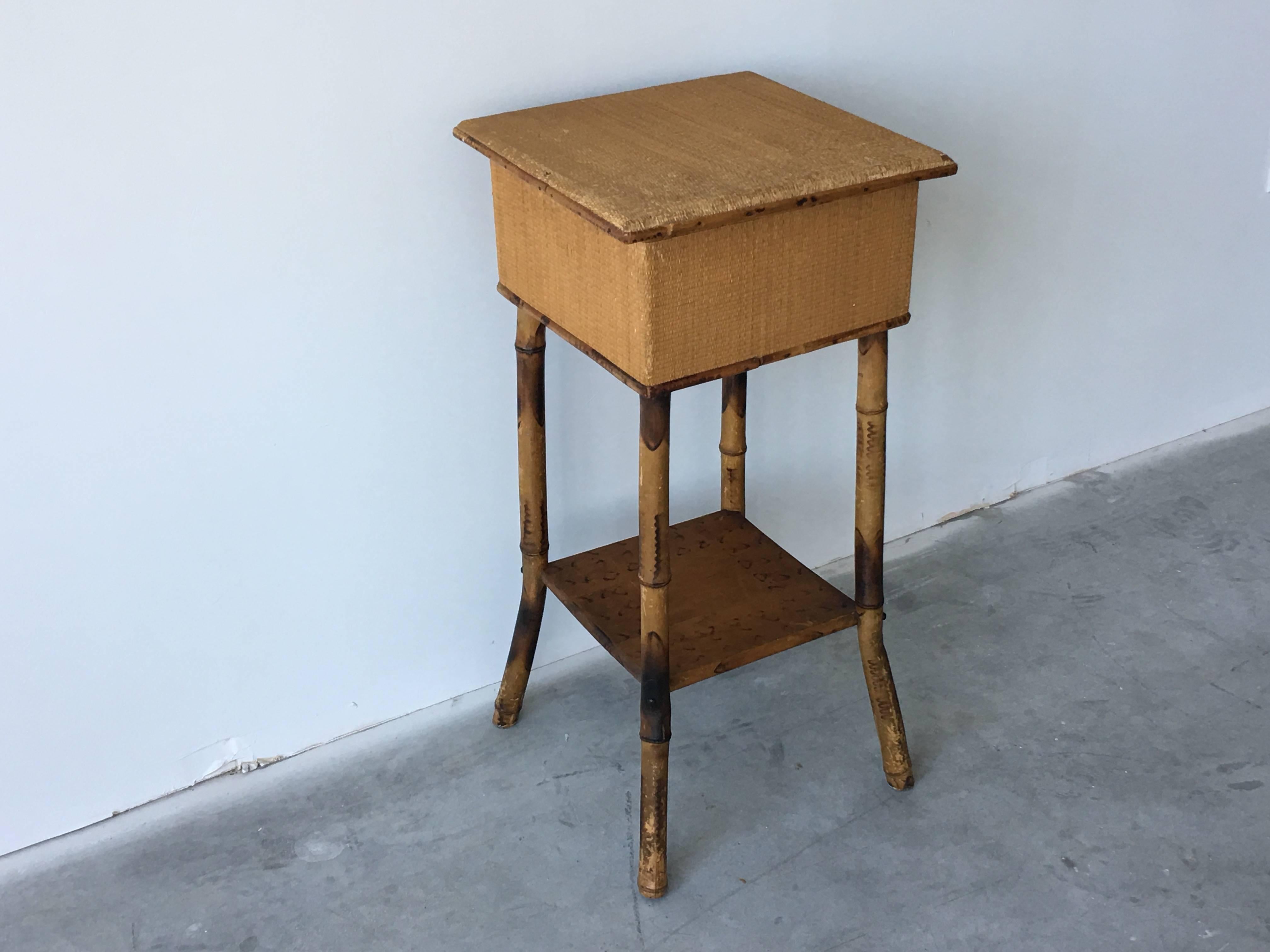 Offered is an elegant, 1920s bamboo and raffia lift-top side table. Could also make a perfect plant stand. Inside is a removable four divided compartment.