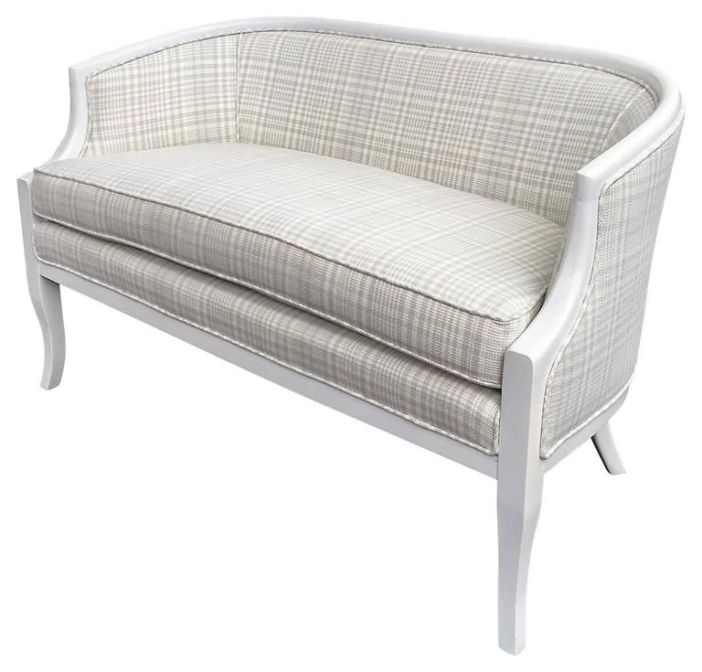 1950s, small-scale curved back settee, newly painted in glossy white and reupholstered with a cream and pale blue Hodsoll McKenzie woven check fabric for a photo shoot. Reversible seat cushion with back zipper; Dacron wrapped seat cushion. Both arms