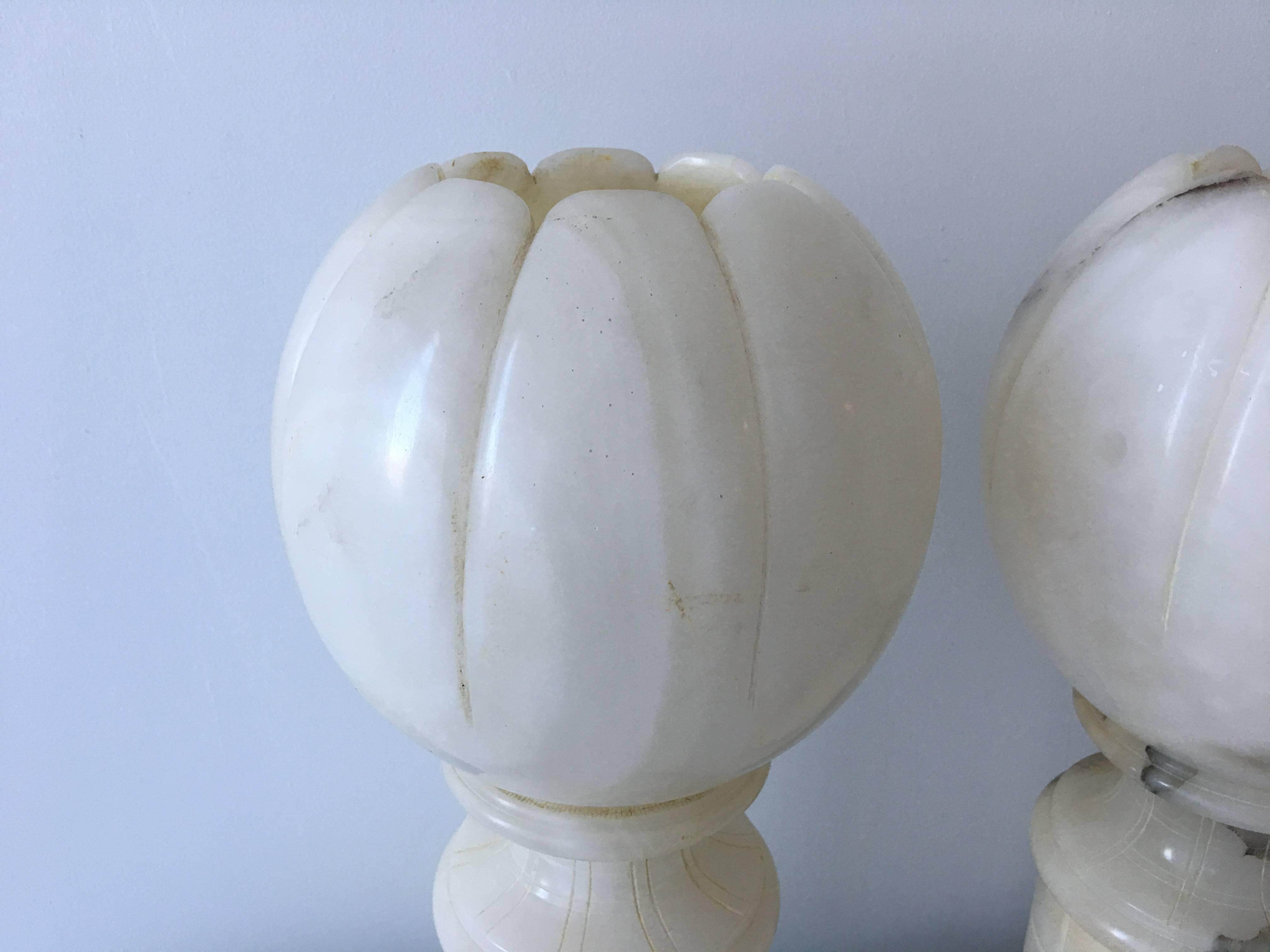 Offered is an exquisite pair of 1920s Art Deco, solid alabaster urn lamps in the shape of orbs. These are absolutely stunning, giving off great ambient lighting. Wiring is in excellent condition.