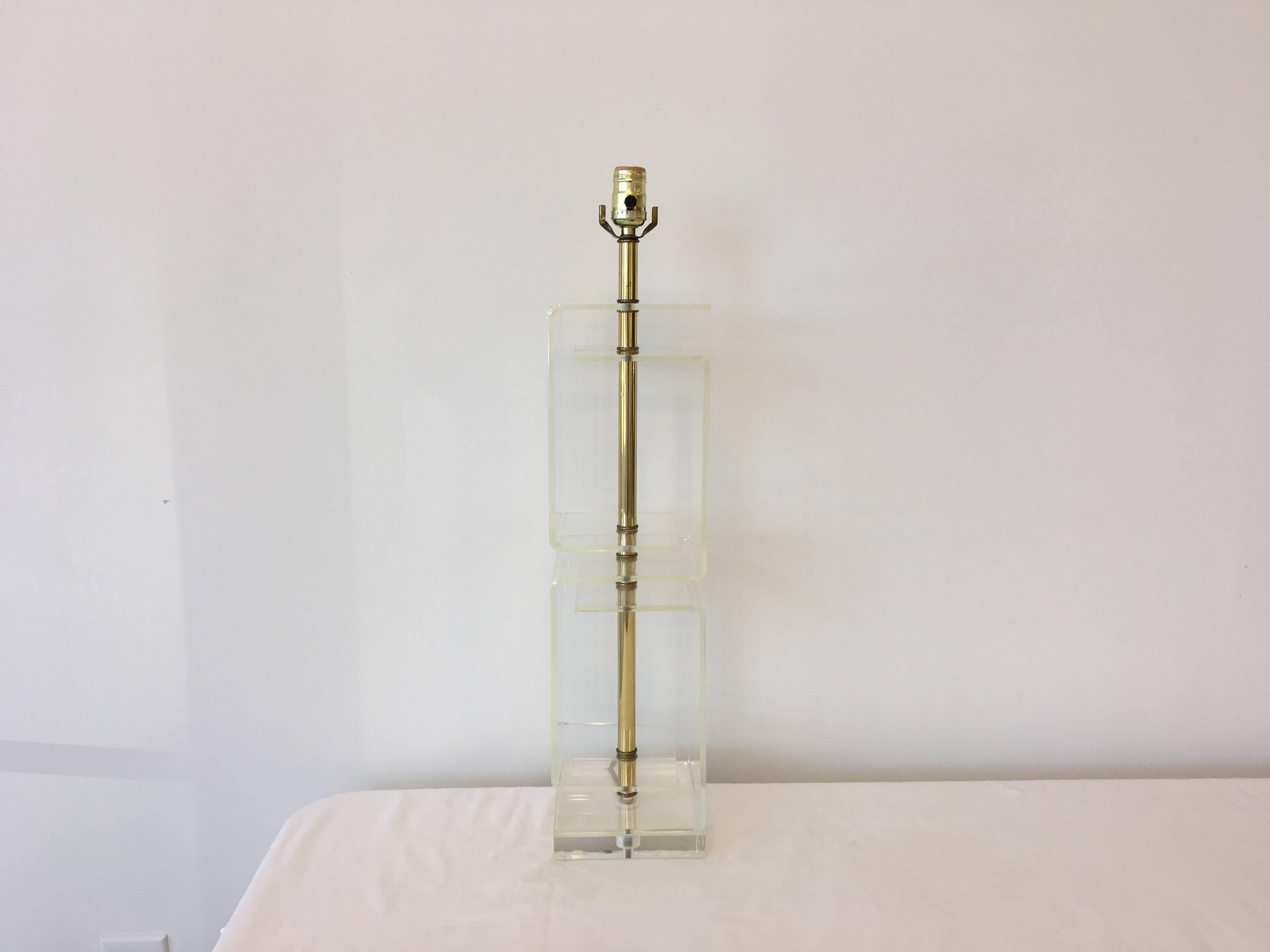 Offered is a stunning, 1960s Mid-Century Modern, Lucite table lamp. The piece features brass accents and a large, Greek key pattern Silhouette (the four cubes stacking).