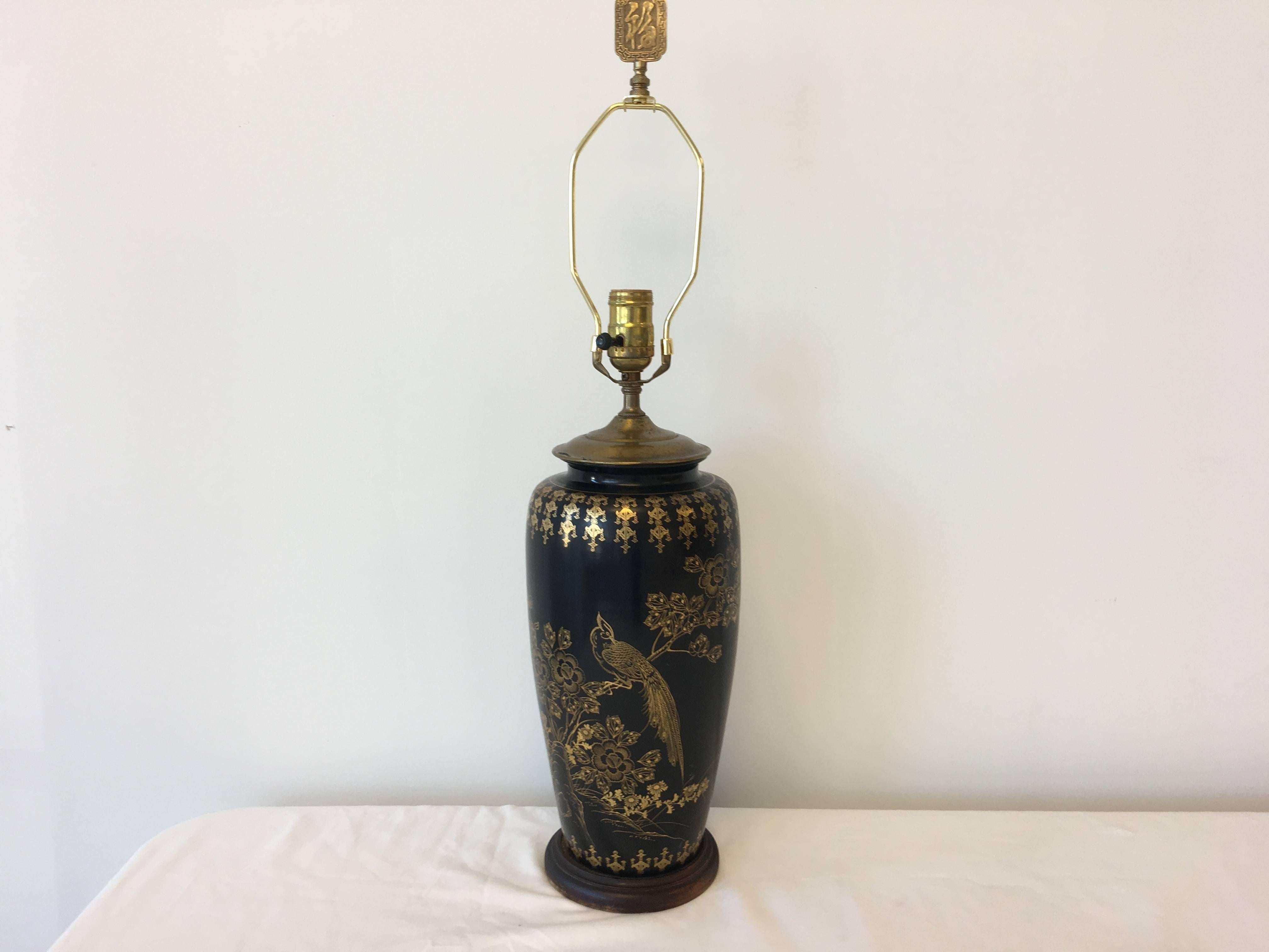 Offered is a beautiful, 1950s black and gold hand-painted, chinoiserie tole table lamp. This lovely piece, features a hand-painted peacock and floral motif that wraps around the entire lamp. Rests upon a dark mahogany base. 

18