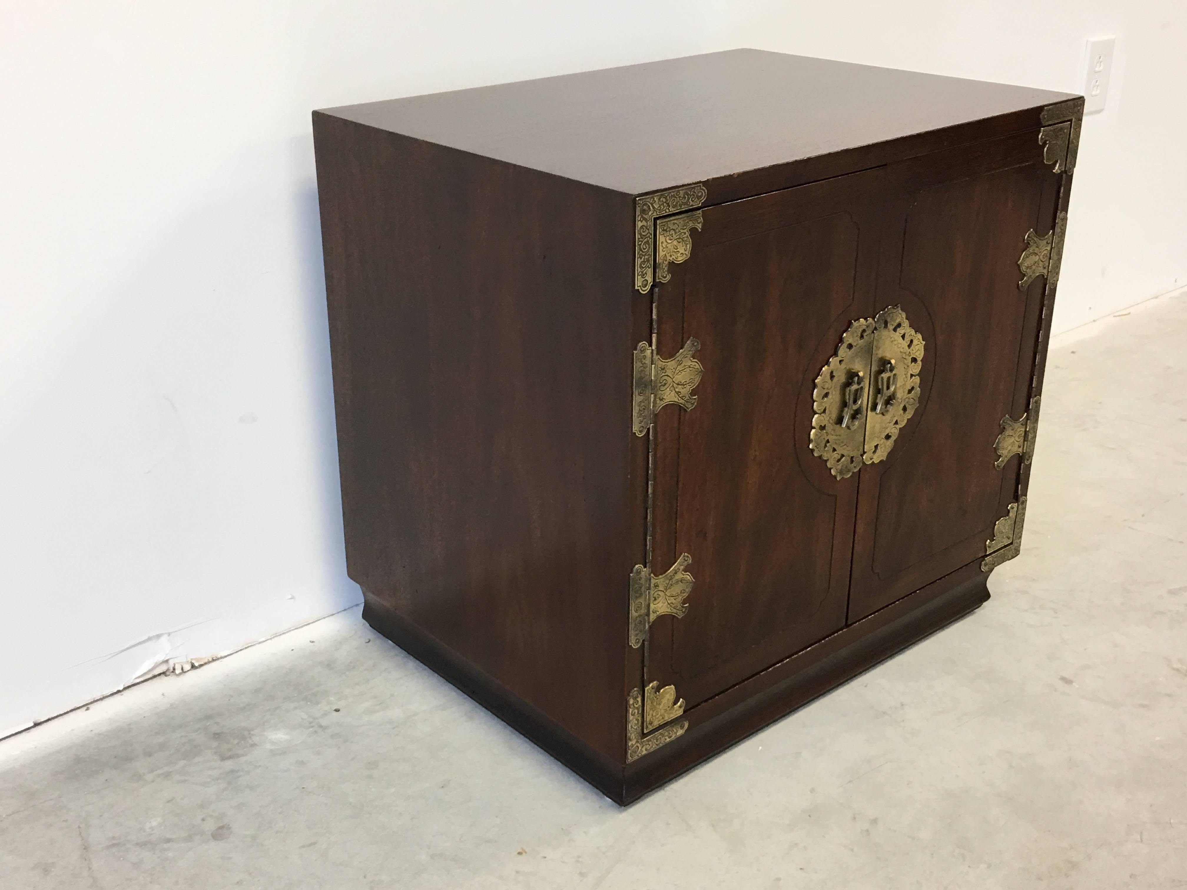 Offered is a stunning, 1970s Henredon, Asian Style Campaign chest with intricate brass hardware. Doors open up to storage, with a single shelf. Four electrical holes cutout along the backside, convenient for phone or computer chargers.