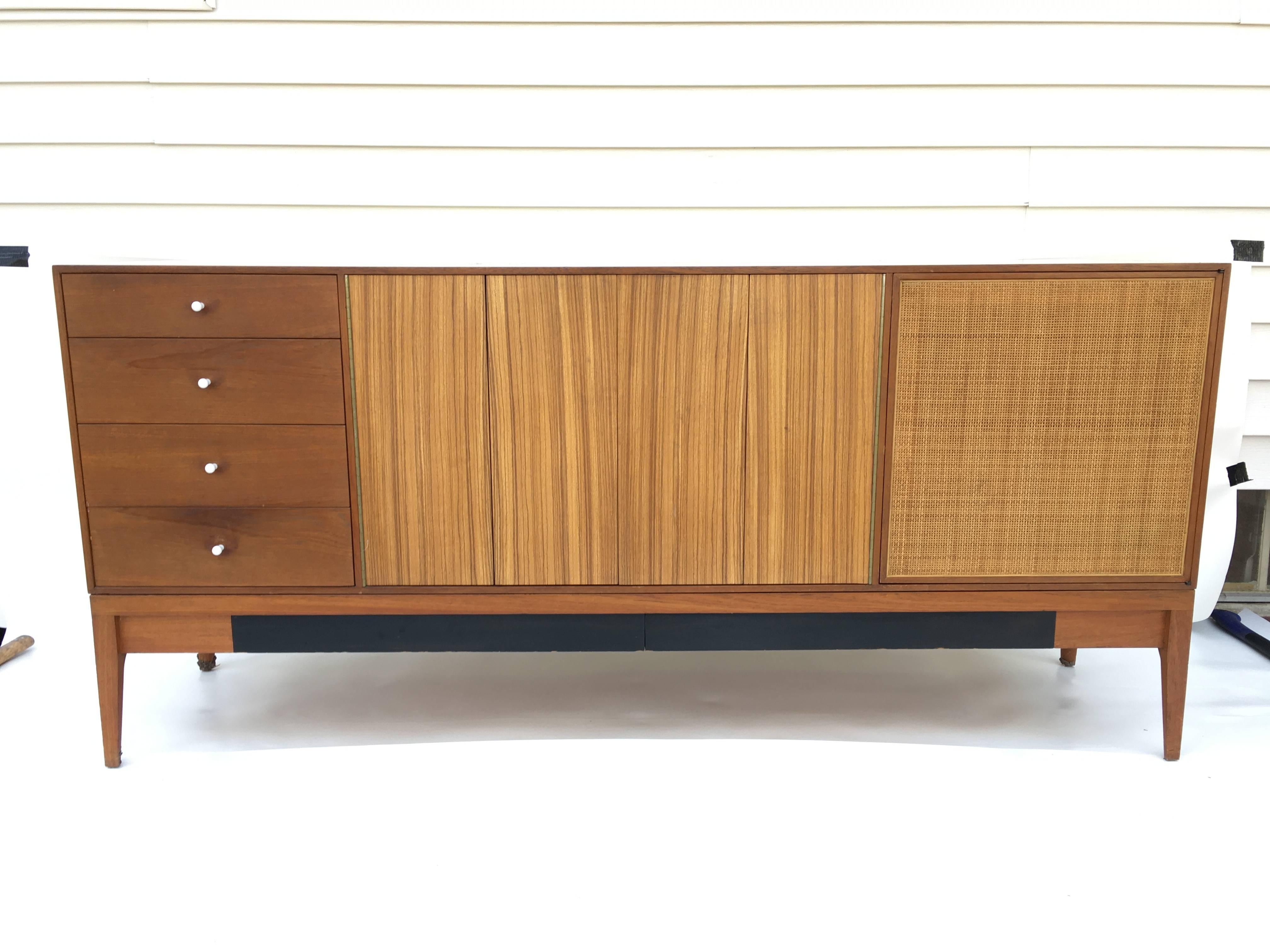 Offered is an incredible 1950s modular dresser by Grosfeld House. This dresser is composed of three pieces. The top piece rests on the dresser below and features two spring loaded doors which open up to shelves, drawers and a lift-top dressing