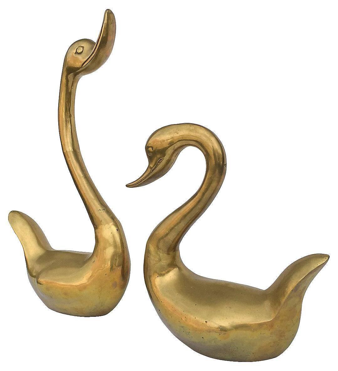Offered is a beautiful, pair of over-scale Midcentury solid brass swans. They have no maker's mark. There is a light patina on each of them.

They are in two different sizes: Swan with raised neck, 19" H x 11" L x 5.5" W; swan with