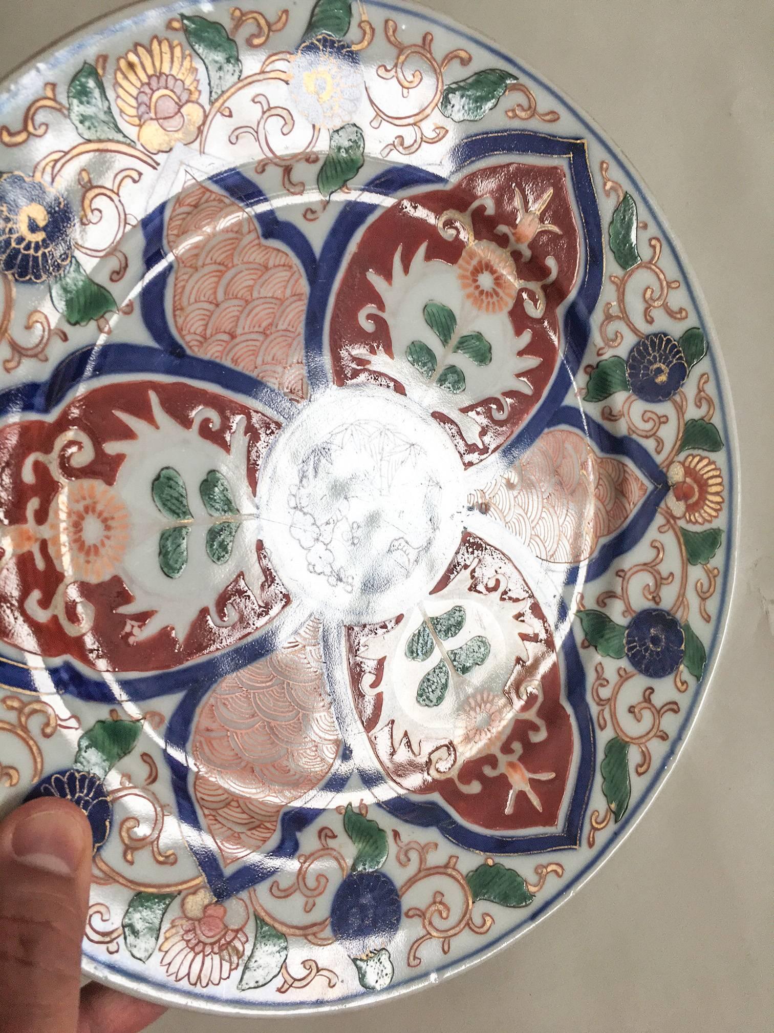 Offered is a striking, late 19th century antique Chinese Imari plate, decorated in rich overglaze and underglaze hand-painted tobacco leaf motifs in polychrome colors of navy blue, orange, emerald green, and russet on a white ground.

Excellent