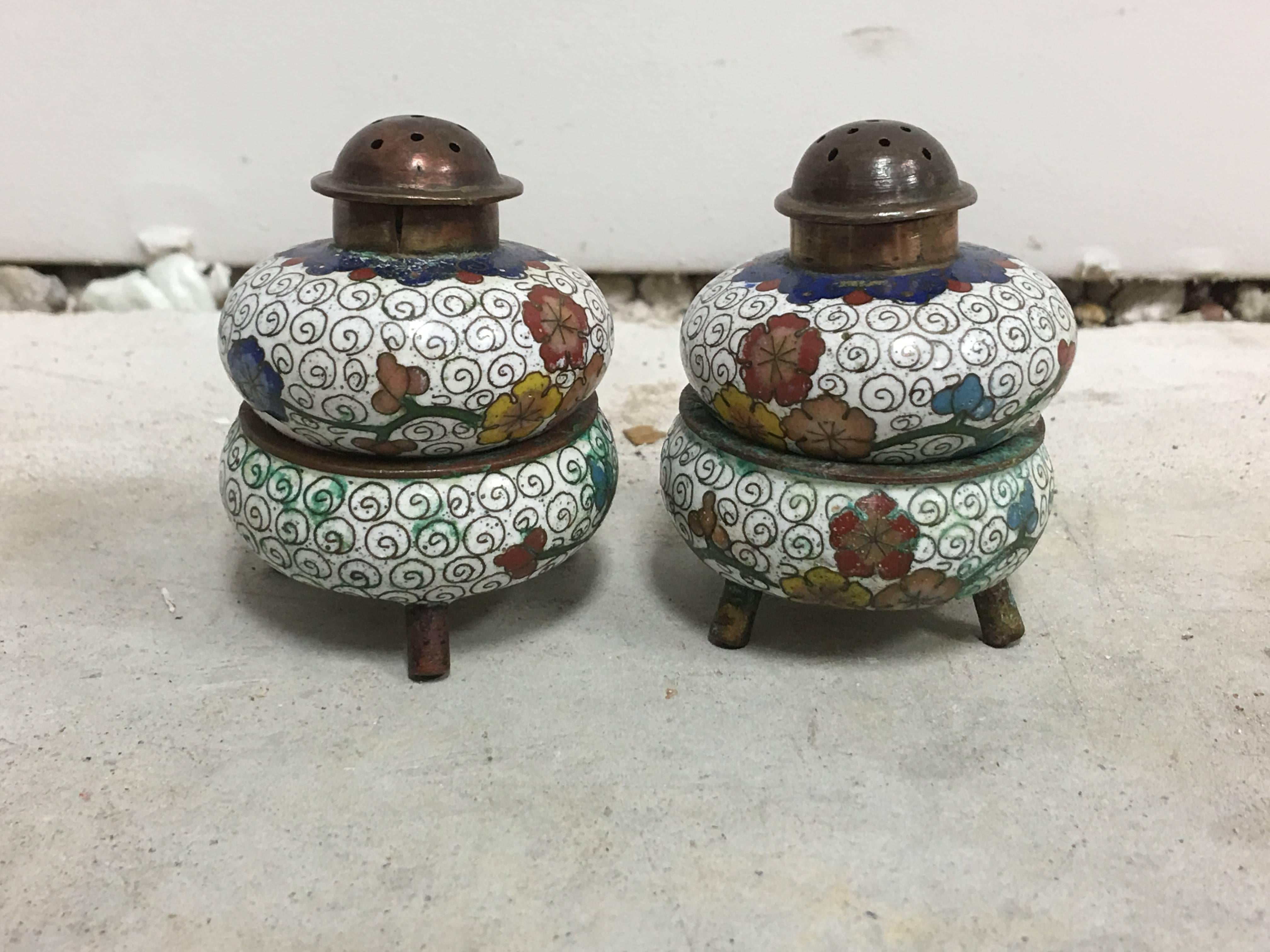 Offered is a stunning pair of white, 1930s Cloisonné salt and pepper shakers with stands.