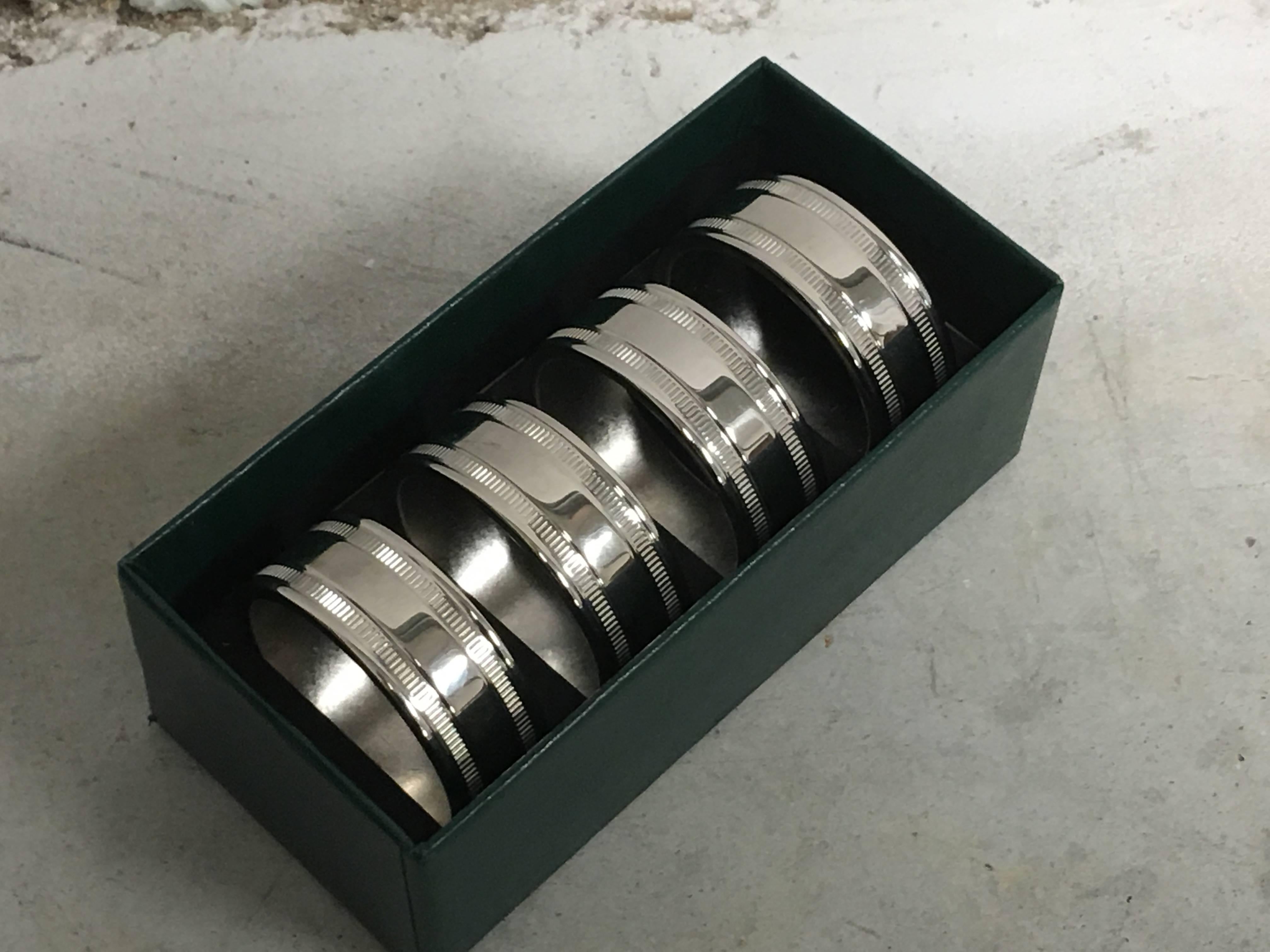 Offered is a truly immaculate, set of four 1980s Virginia Metalcrafters silver plated brass napkin rings. Includes original box, never used. Substantial weight.