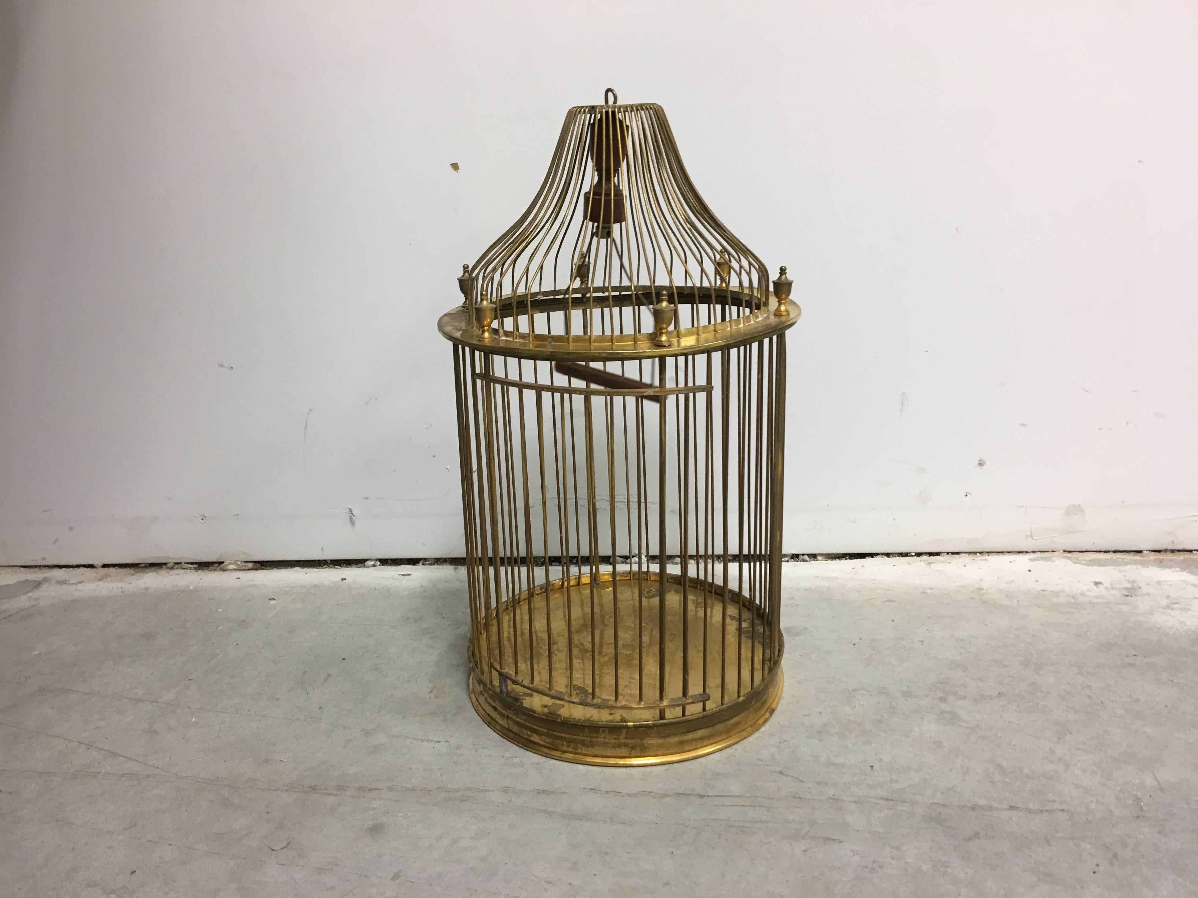 Offered is a beautiful, 1960s, Mid-Century Modern, brass birdcage with decorative finials and a hinged door.