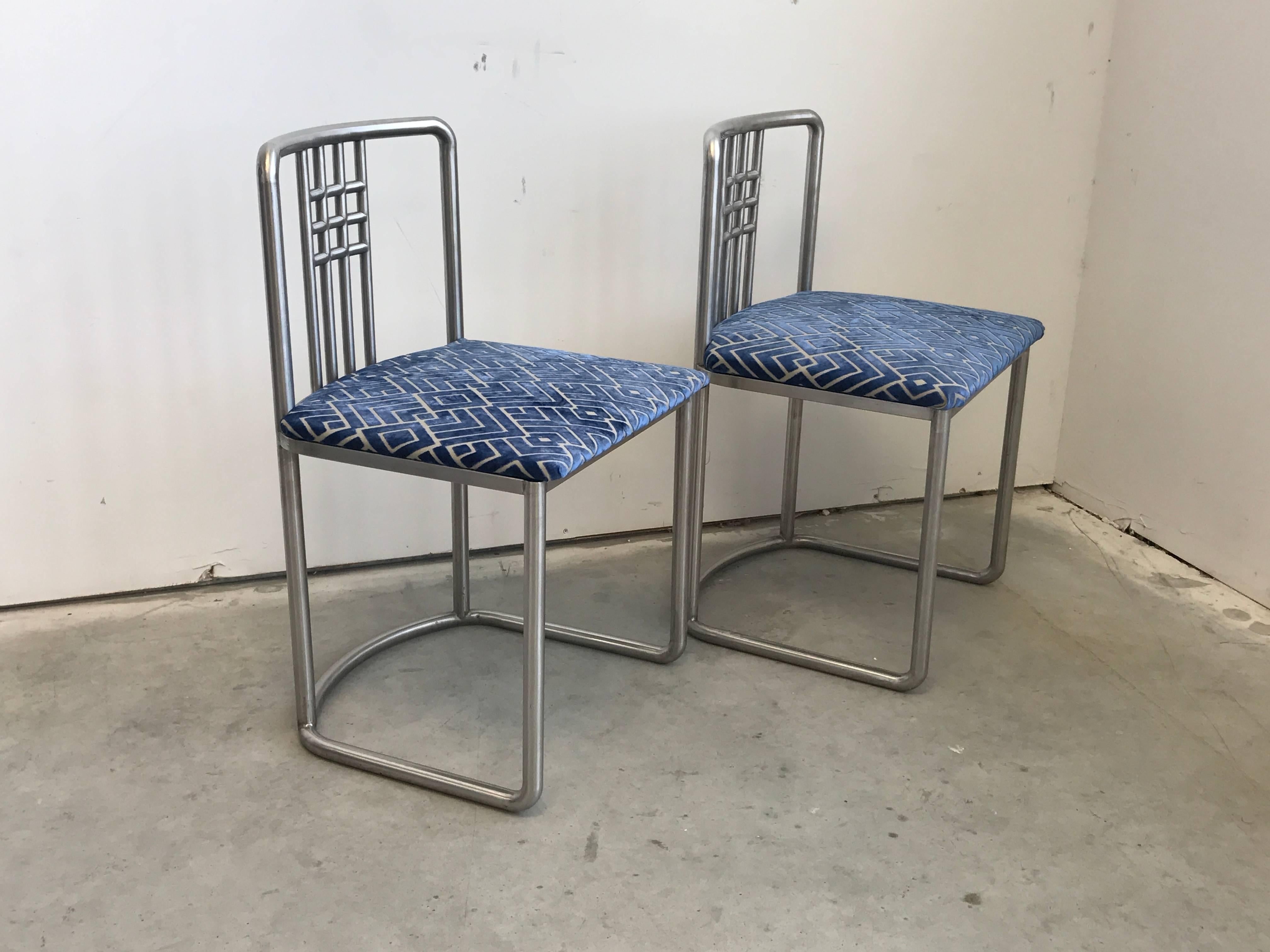Offered is a stunning pair of 1970s, Frank Lloyd Wright styled, stainless steel side chairs with a modern, blue and grey cut velvet upholstery. One of a kind and sturdy.