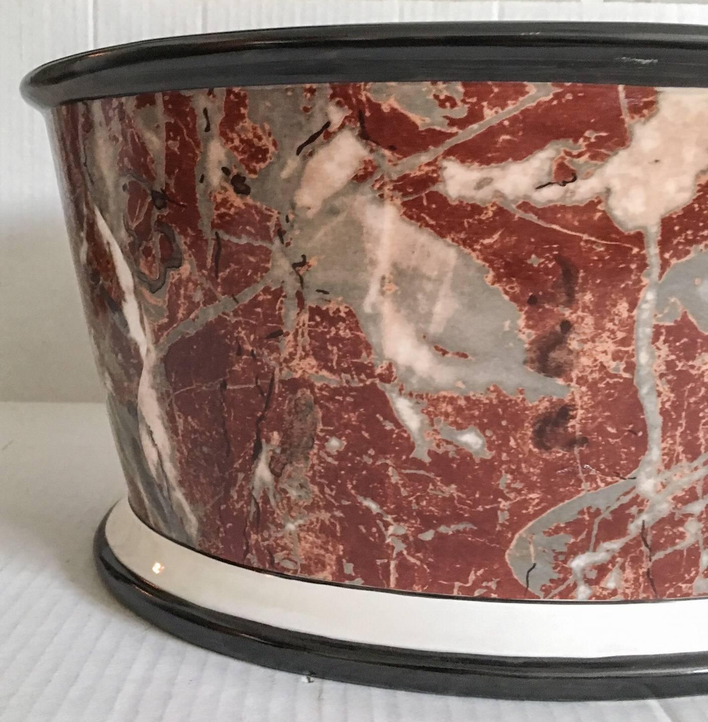 Offered is a superb large-scale oval hand-painted jardiniere, decorated in the trompe l'oeil style with a reddish orange marble motif, finished with black banding along the top and bottom against a cream ground. Marked "Made in Italy;"