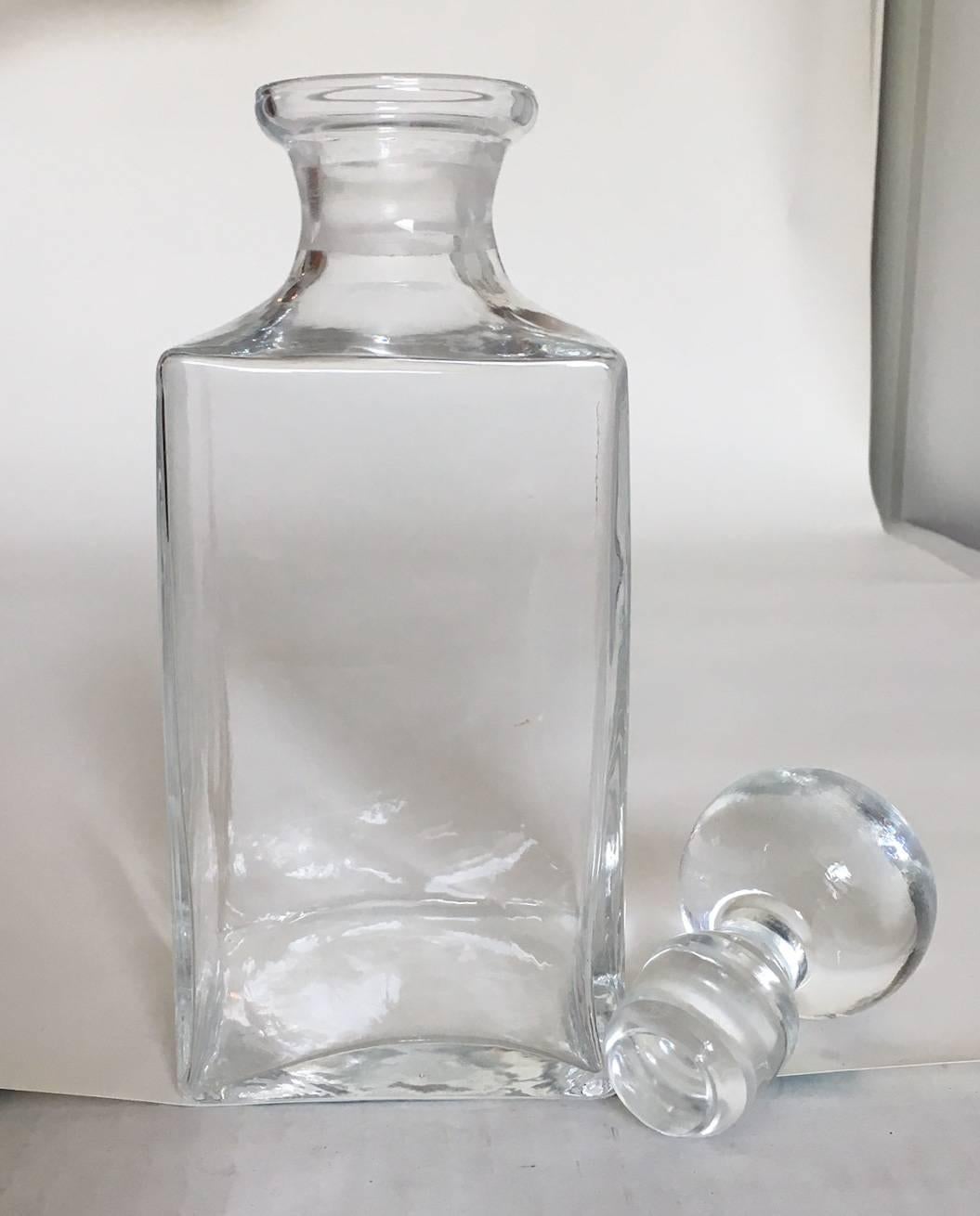 Offered is a collection of five handblown glass decanters with original stoppers, dating to the mid-late 19th century. Dimensions of each from left to right: square decanter, 3.75" L x 3.75" W x 10" H; bottle form decanter with cloudy