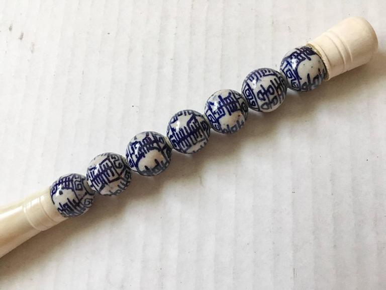 Chinese calligraphy brush with a cream bone and blue and white bead handle with natural horsehair bristles. Measures: 11.25