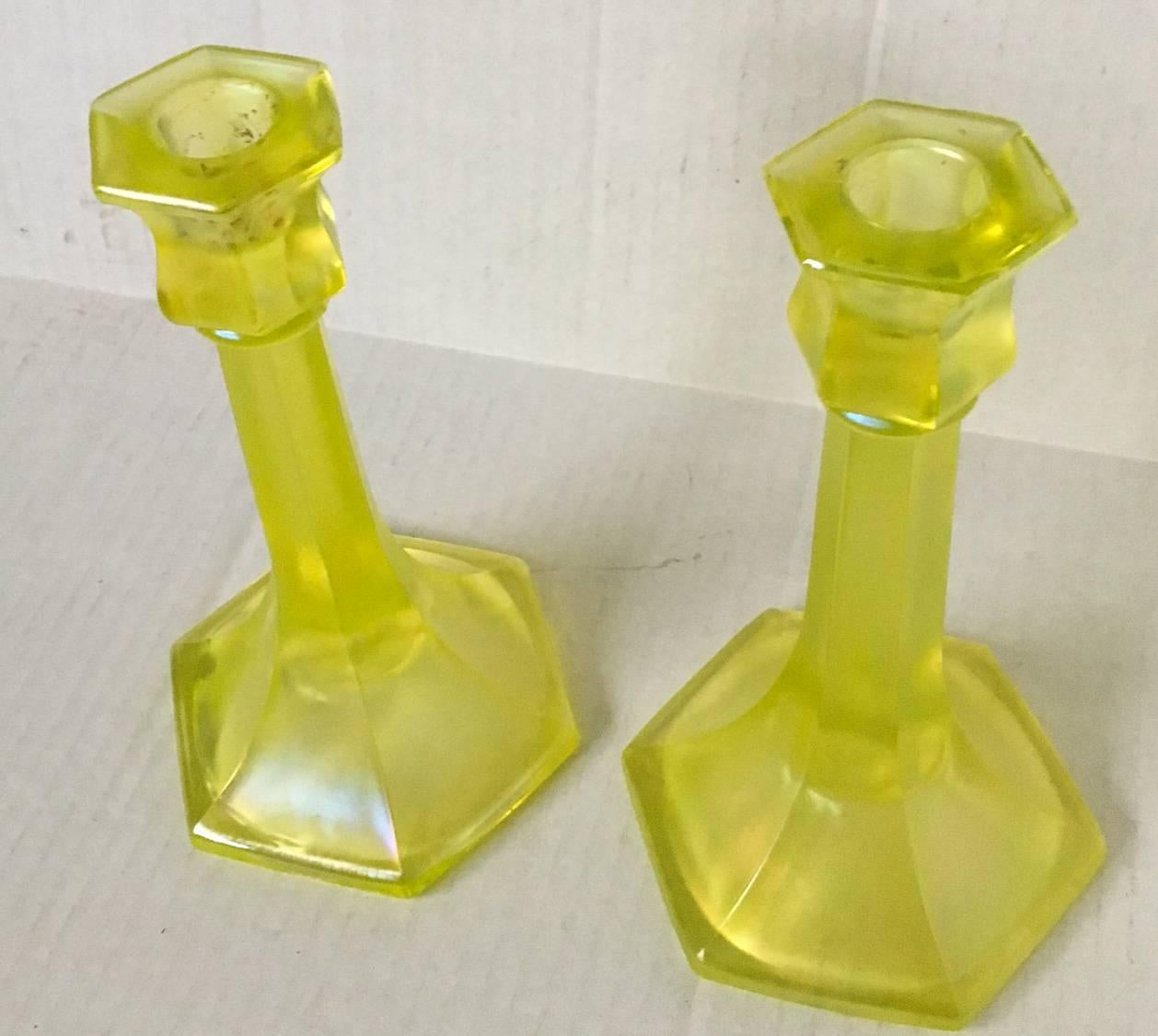 Excellent pair of American pressed glass iridescent greenish yellow candlesticks referred to as "Vaseline" glass. Unmarked, most likely created by a New England glass factory. Each, 5" diameter x 8.5" height.