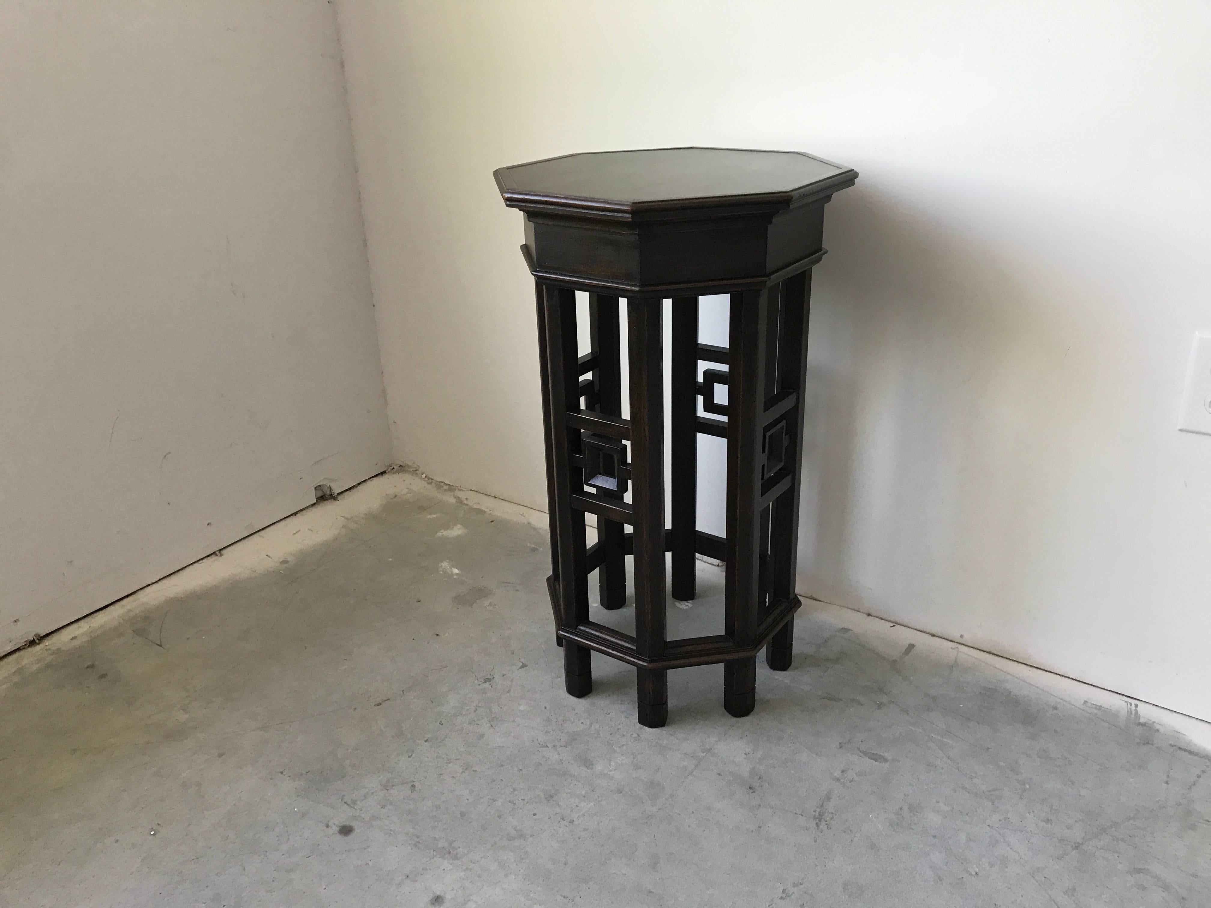 Offered is a beautiful, 1960s Asian fretwork octagon side table in a dark walnut or ebony color. Extremely sturdy. Perfect as a side table, pedestal, or plant stand.