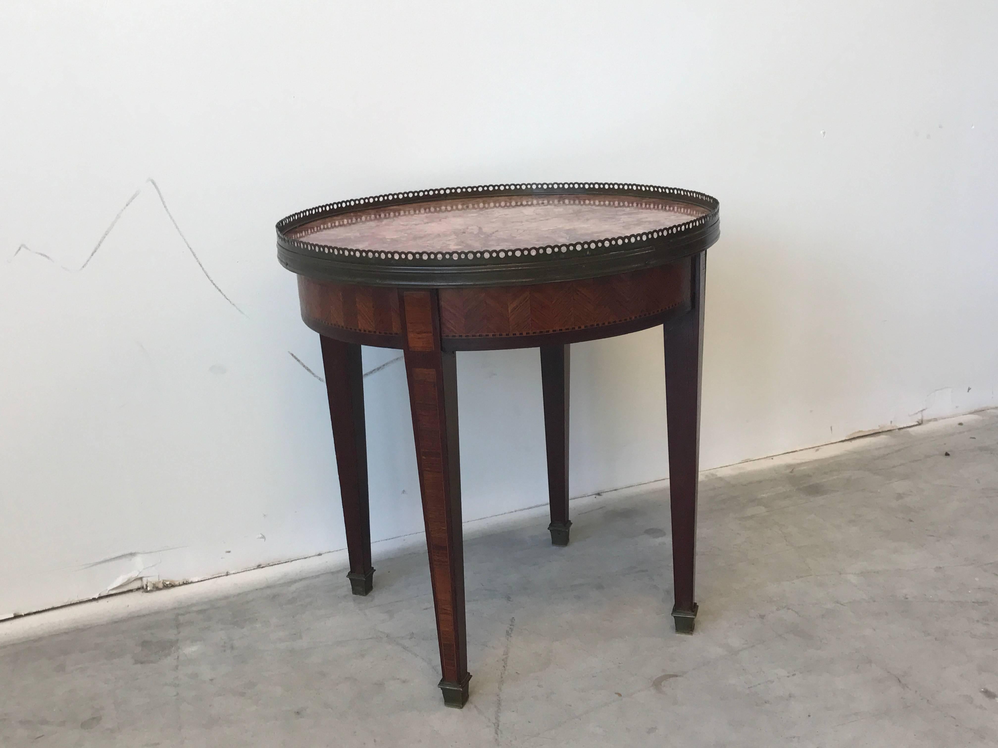 Offered is an immaculate, early 19th century, French marquetry guideron side table with a pink marble top. The piece is complimented by brass toe caps and brass gallery edging. Finished underside, weighs approx. 30ibs.