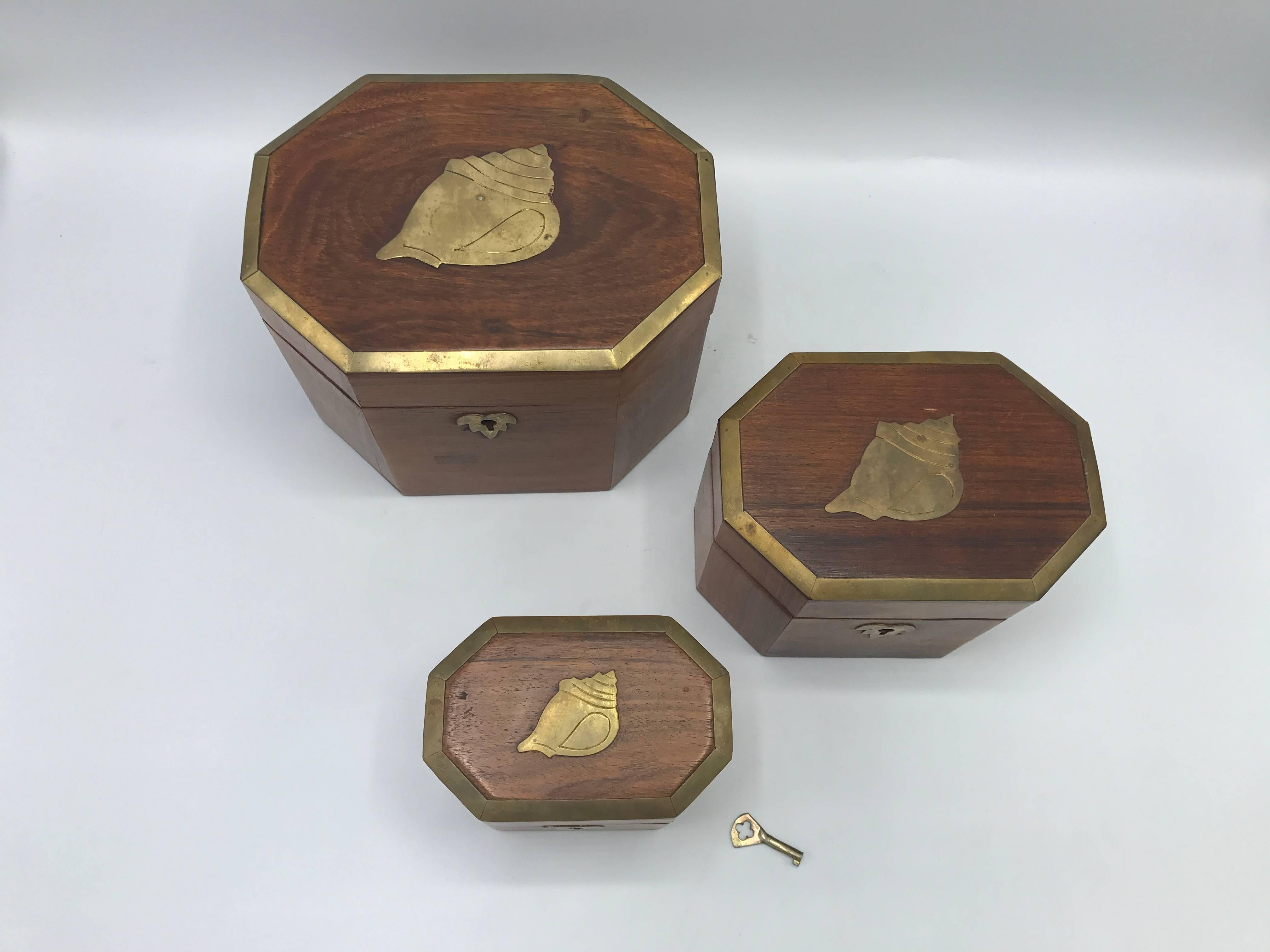Offered is a gorgeous, set of three, 1960s teak nesting boxes with brass seashell and border inlay. Includes original key. 

Large 5.5" x 7.25" x 5.5"

Medium 4.5" x 6" x 4.25"

Small 3.5" x 4.5" x