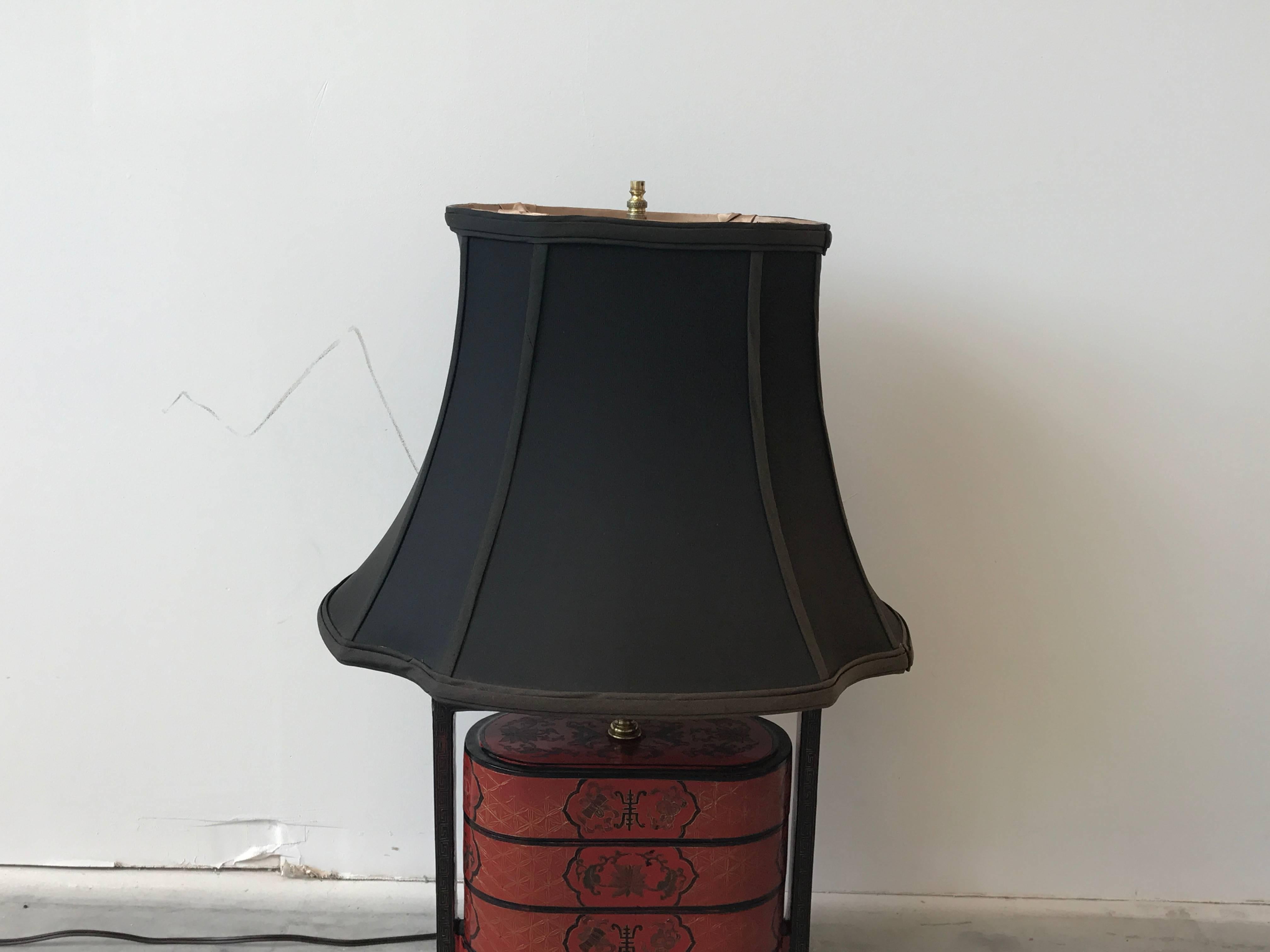 Offered is a fabulous, 1940s Chinese red and black lacquered lamp. The piece is made of converted stacking decorative boxes. Includes shade. Shade is in good, vintage condition.

Measures: 5