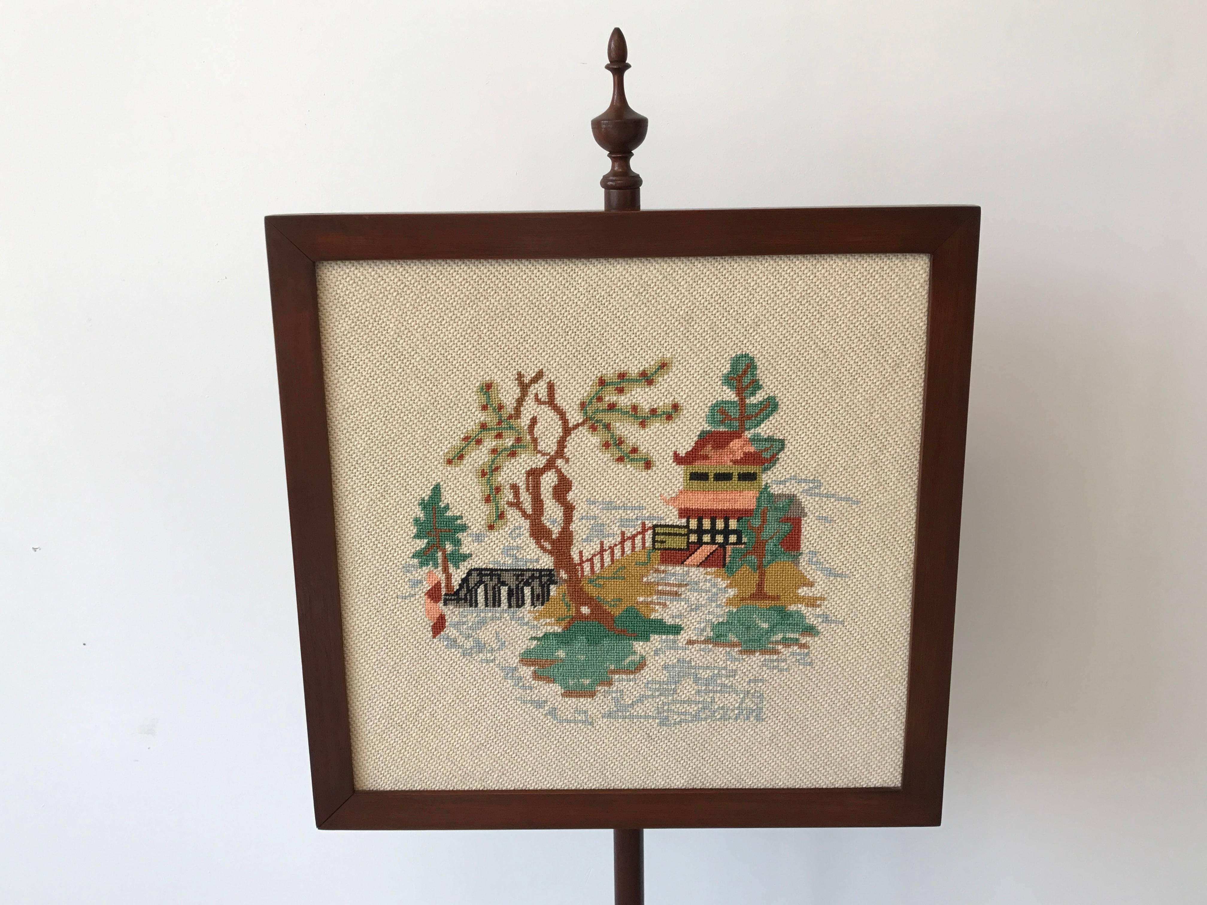 Offered is a gorgeous, 1970s chinoiserie needlepoint fire screen with an ornate pagoda motif. Signed, bottom right of needlepoint. Needlepoint is removable to hang as artwork. 

Needlepoint is 1