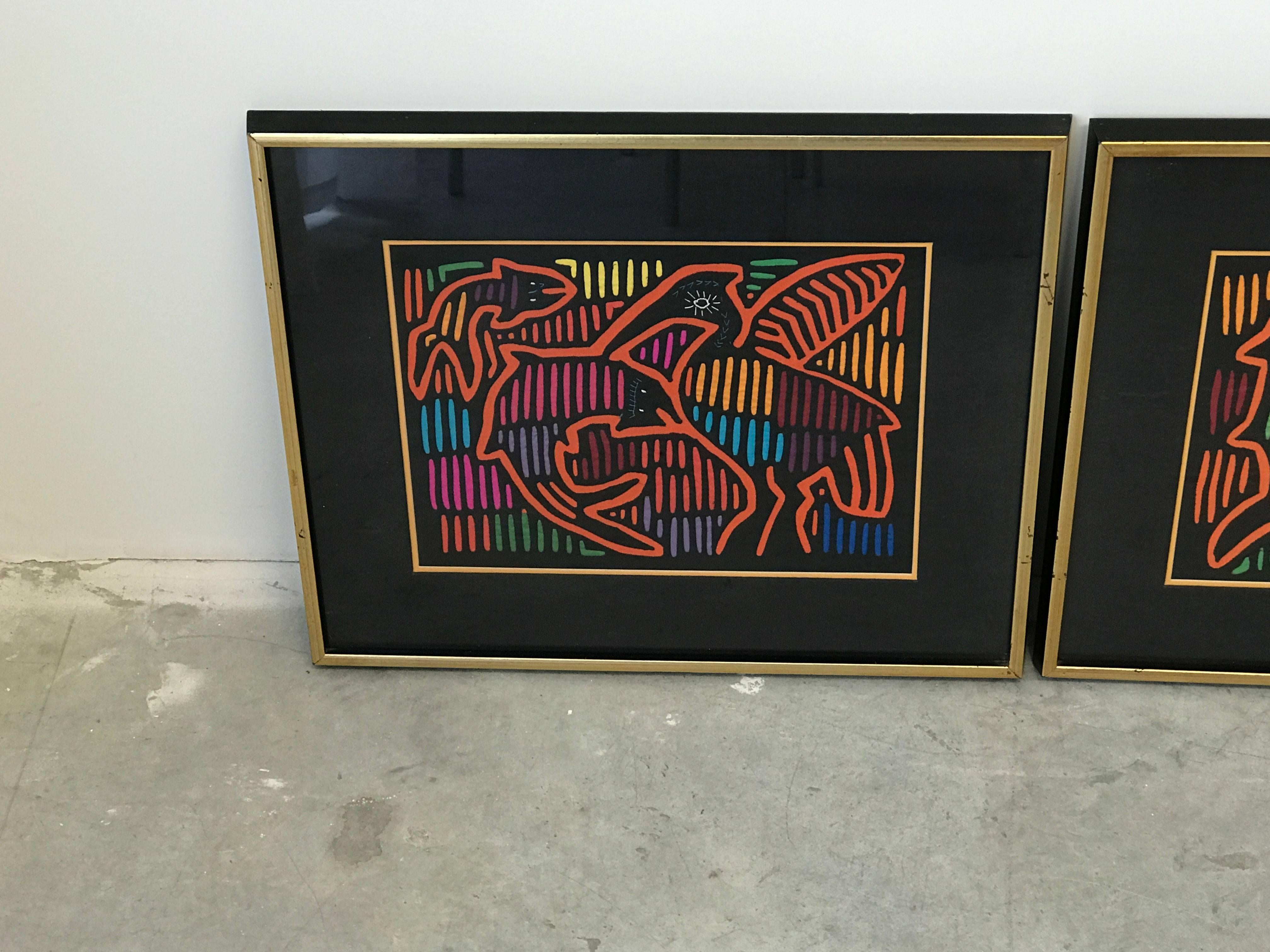 Offered is a stunning, pair of 1970s Guatemalan Mola textile panels framed. One features a fish and bird motif, the other is a fish and mammal motif. Each are framed in a thick black and gold frame, behind glass. 

Molas are handmade using a reverse