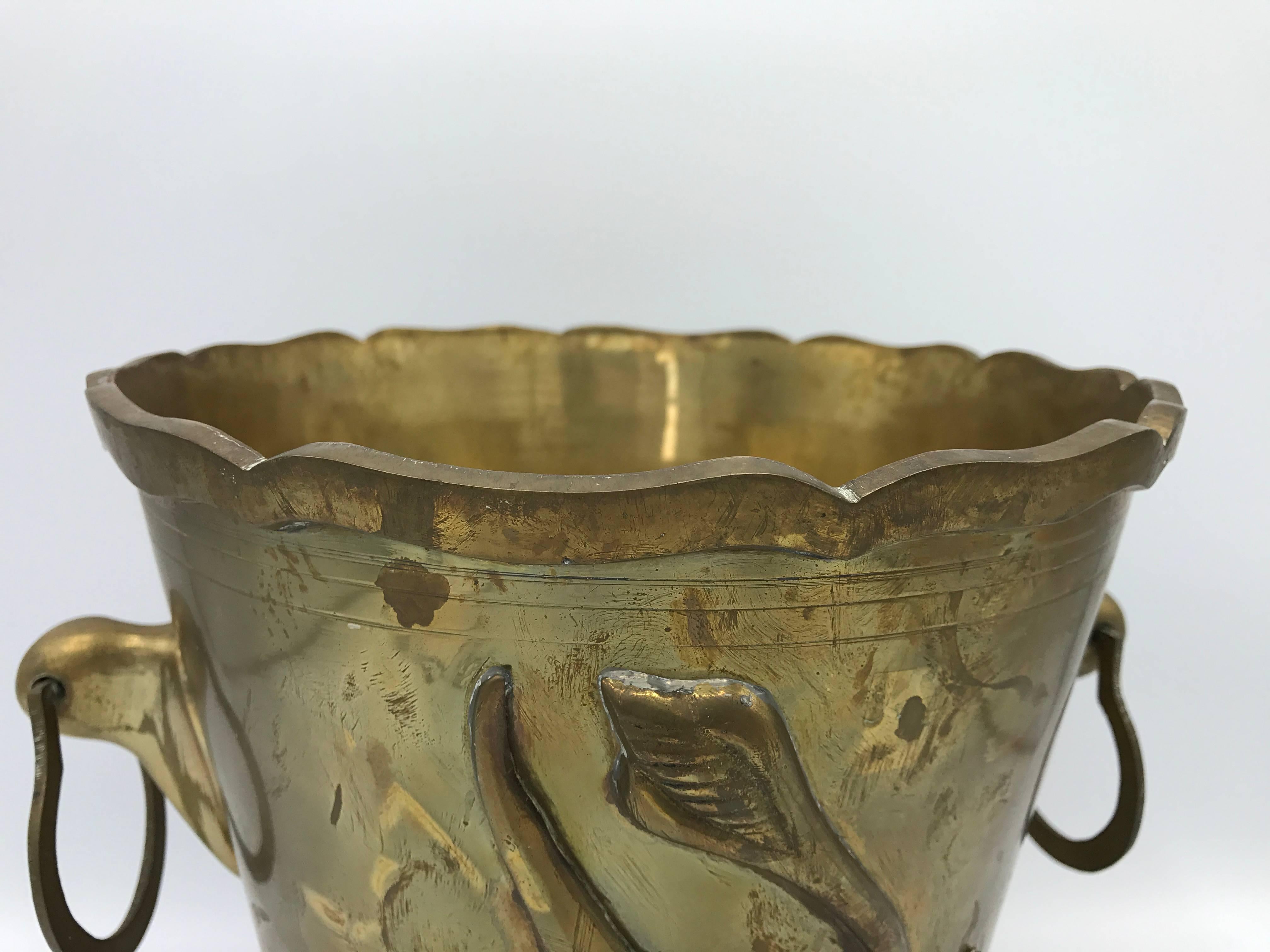 Offered is a gorgeous, 1970s solid-brass Hollywood Regency waste basket with a tulip floral motif on one side. Handles on both sides. Alternatively, can be used as a cachepot or wine chiller. Heavy.