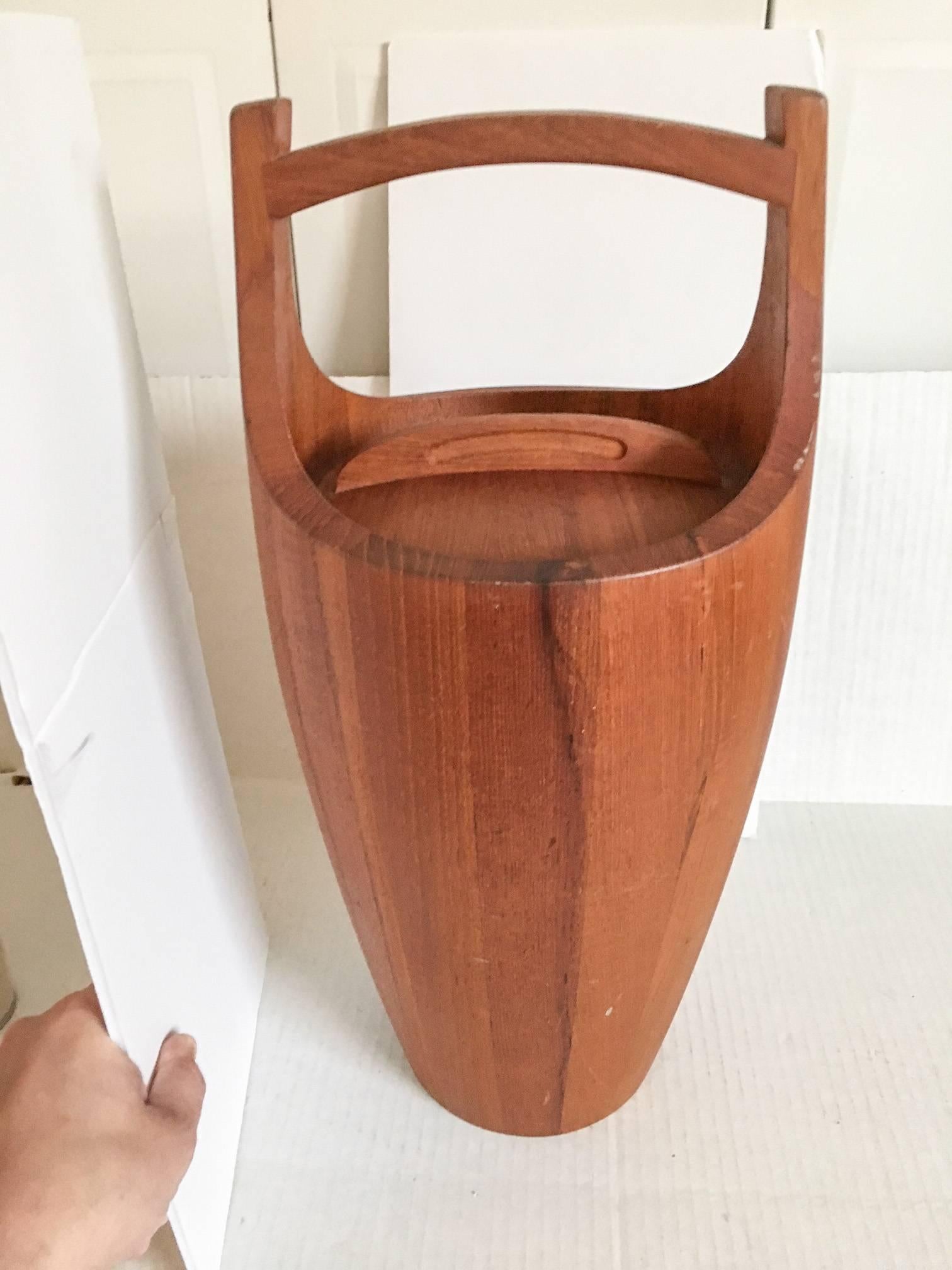 Very large solid teak hardwood Asian-style ice bucket by Dansk. The bucket has a brown plastic interior liner. Marked DANSK on the base. Ice bucket has some scuffs and dings; please review all photographs.