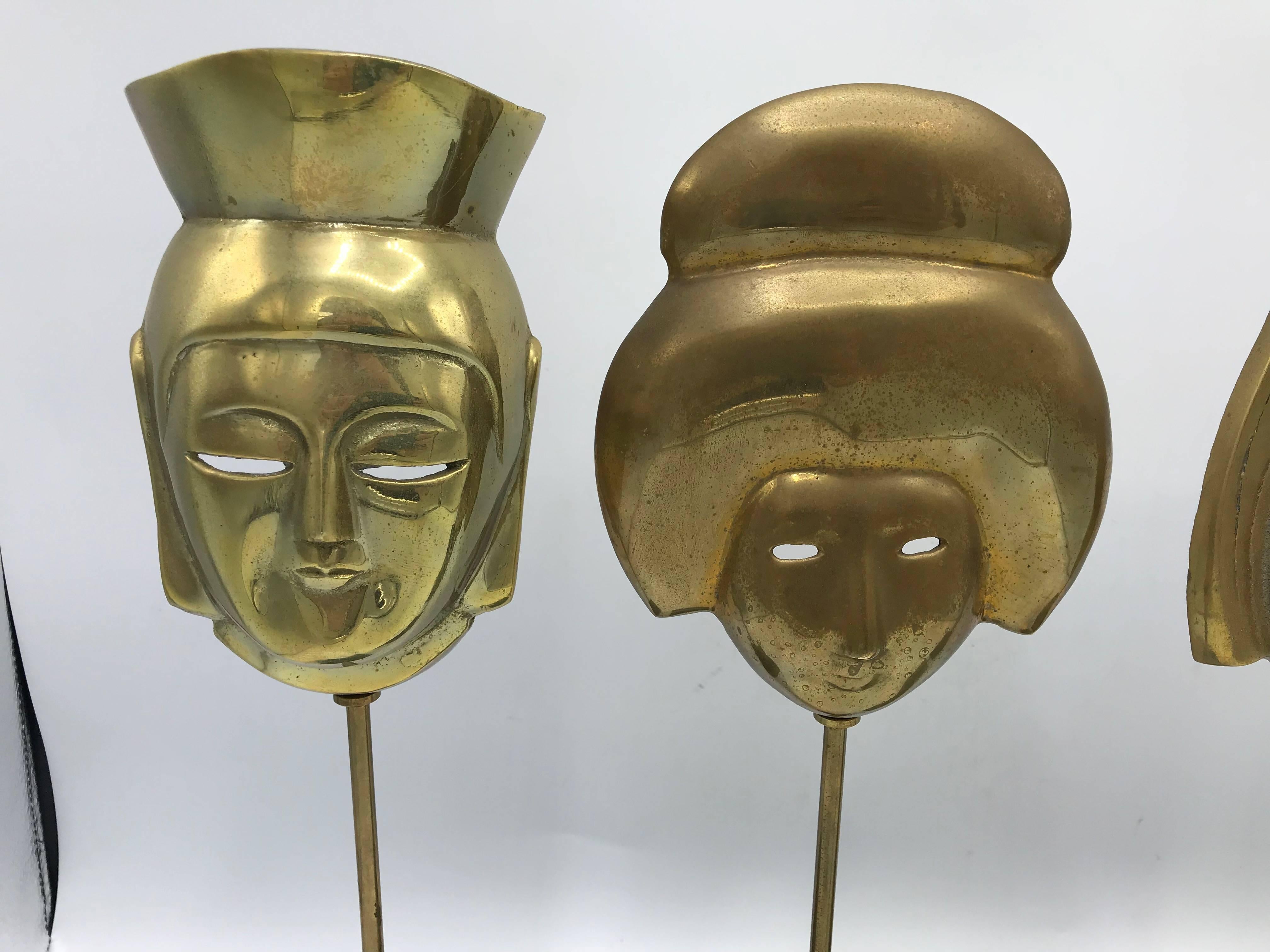 Offered is a stunning, set of four, 1960s, Italian modern brass Asian mask sculptures. Perfect for a bookcase or mantel! Truly beautiful pieces. Bases are 3