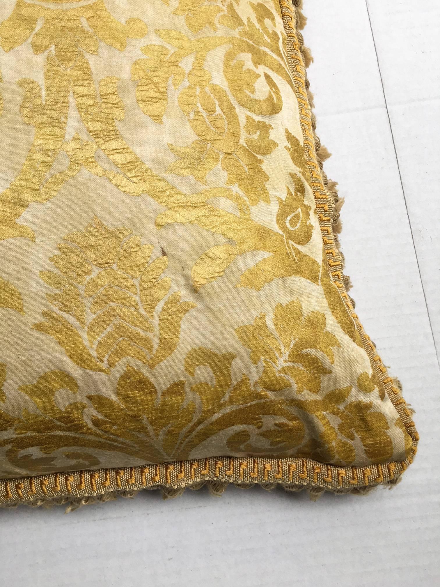 Beyond fabulous vintage Fortuny gold silk damask pillow which reverses to red and gold. The pillow is trimmed in a gold onion fringe. Zipper closure with a newer Ralph Lauren velvet interior pillow to prevent the quills from escaping the down