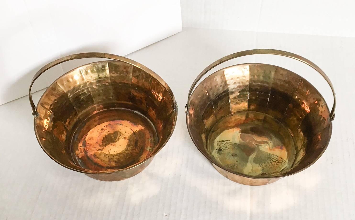 Midcentury circa 1970s, pair of hammered brass fluted baskets with adjustable handles. Both baskets have expected natural brass age patina. Dimensions with handles up: 7.5