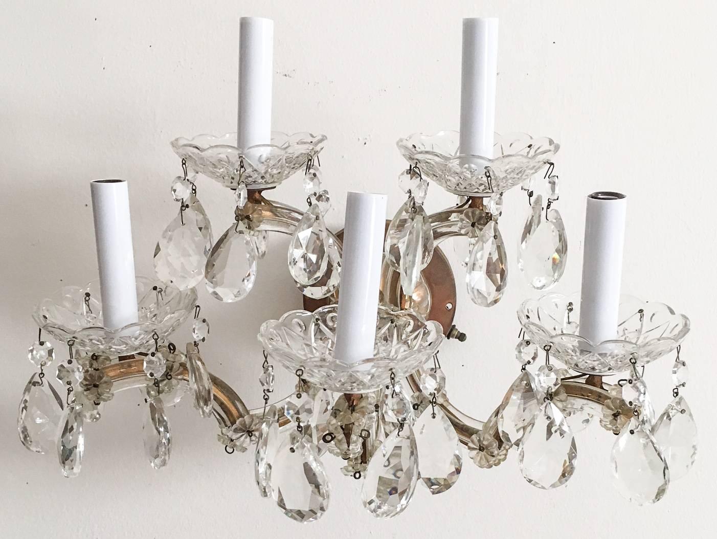 Exquisite pair of 1940s Italian brass and crystal electric wall sconces with original bobeches and candle cups. The body of the sconce has aged to a wonderful warm aged brass finish. Both sconces attach to the wall plate with two screws (not