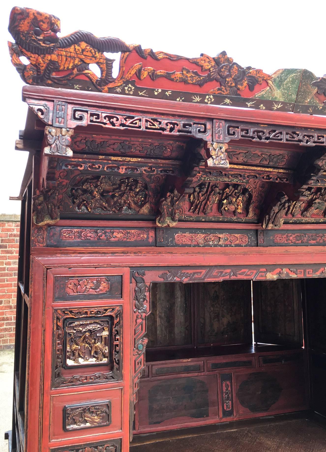 Opt for drama with this late 19th century Chinese opium canopy bed, crafted of elmwood. The exterior is heavily decorated with gold leafing, carvings, ornate carved figurine pillars, and delicate fretwork. The interior features eight, hand-painted,