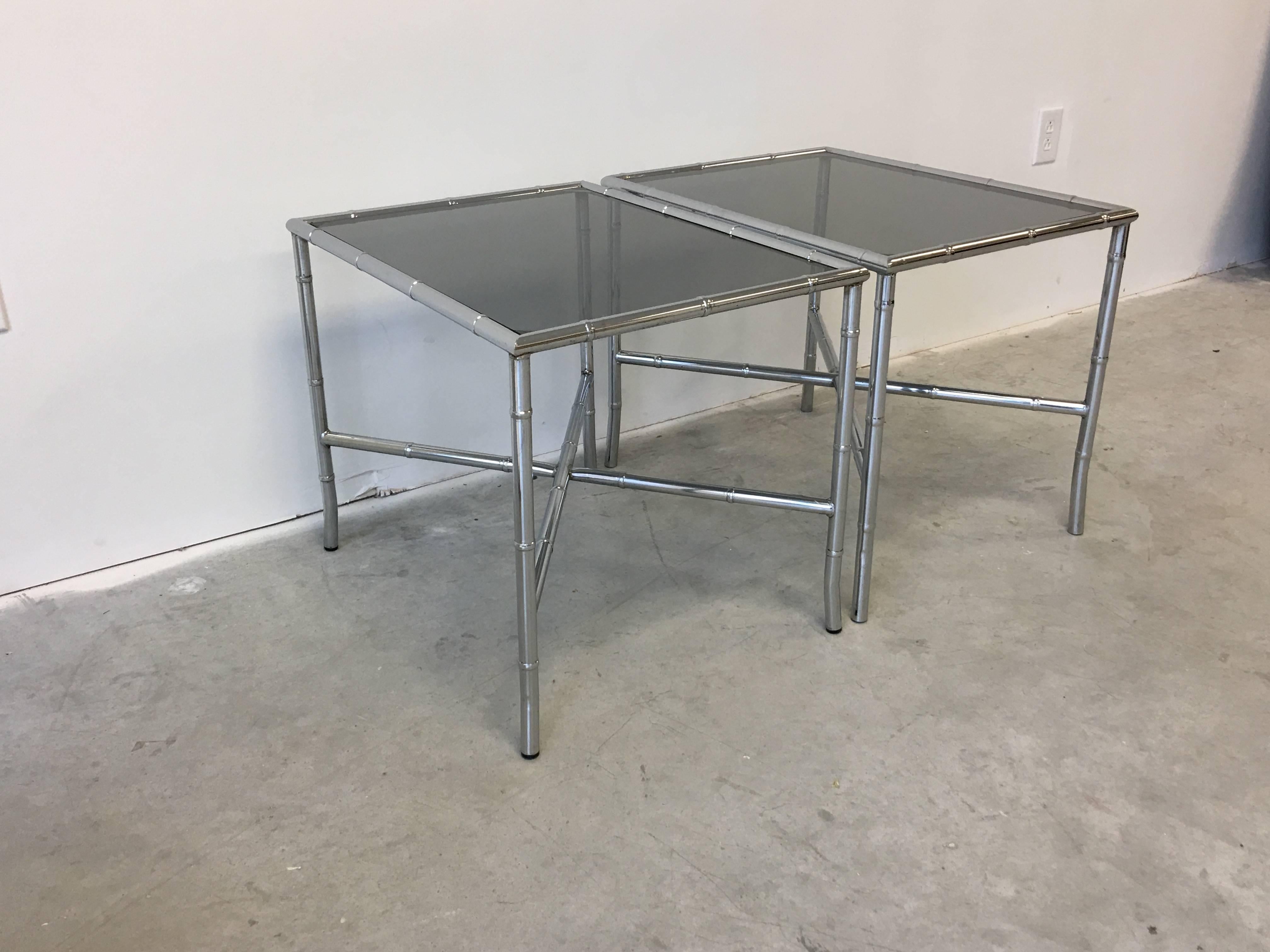 Offered is a beautiful, pair of 1970s chrome faux bamboo side tables with smoked glass tops.