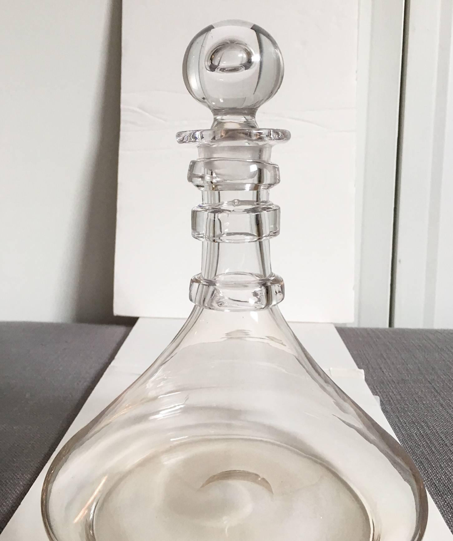 Exquisite blown crystal clear glass decanter in the manner of the American glass firm Steuben with a pontil mark. Decanter has three thick rings around the neck and an unusual air bubble stopper. The underside of the stopper and decanter are both