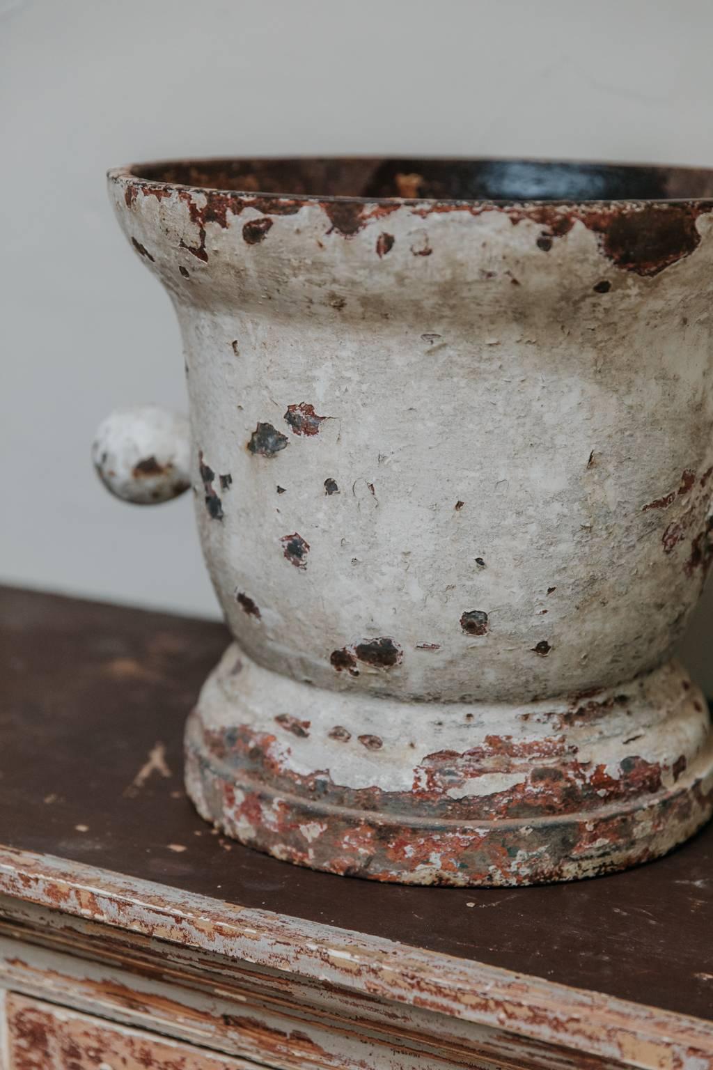 This is a cast iron mortar, with rests of old paint, very charming object, indoors as well as outdoors.