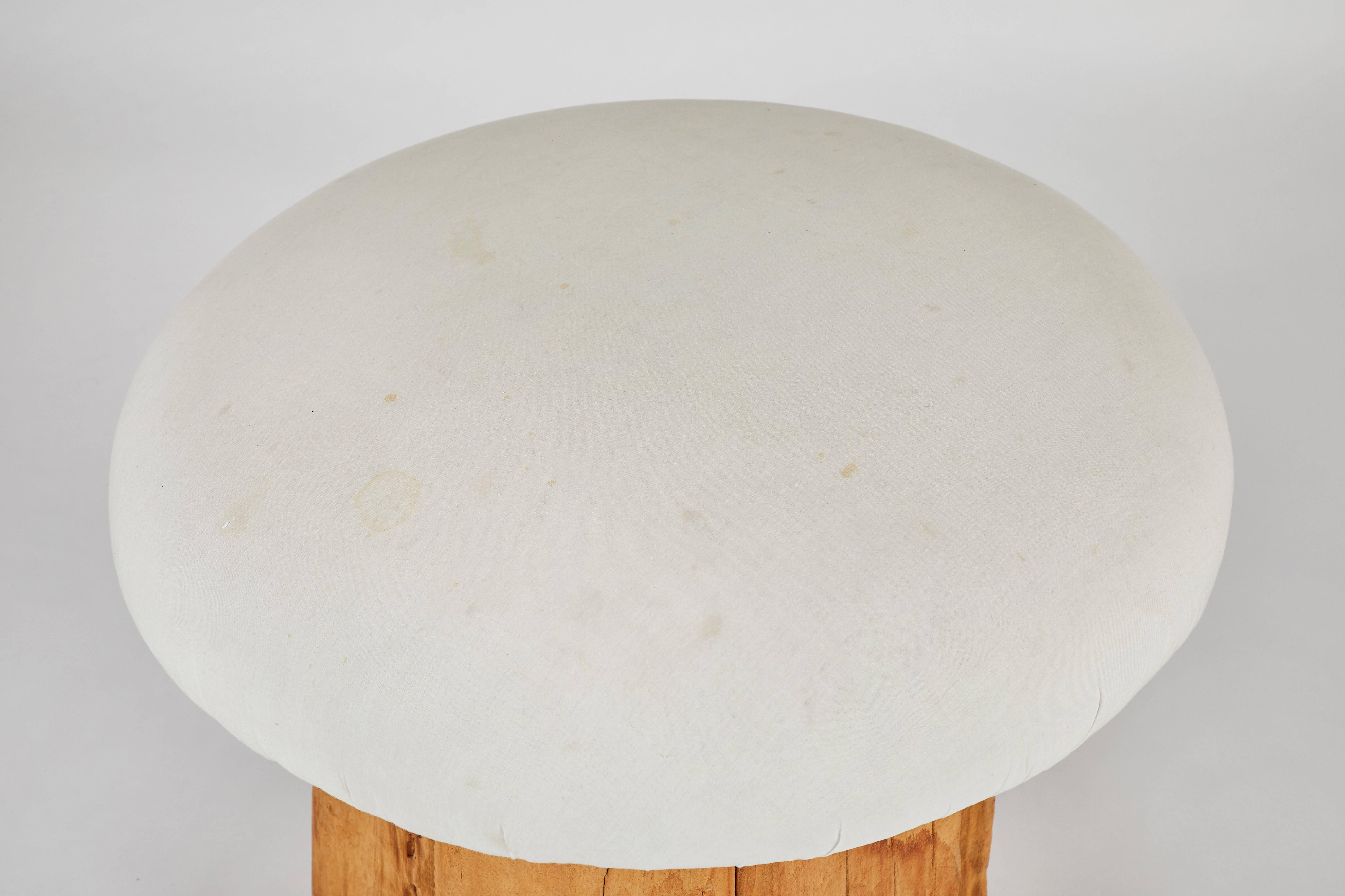 Small mushroom style stool by Michael Taylor. Upholstered plush top (Ivory muslin fabric) with swivel and hardwood base.