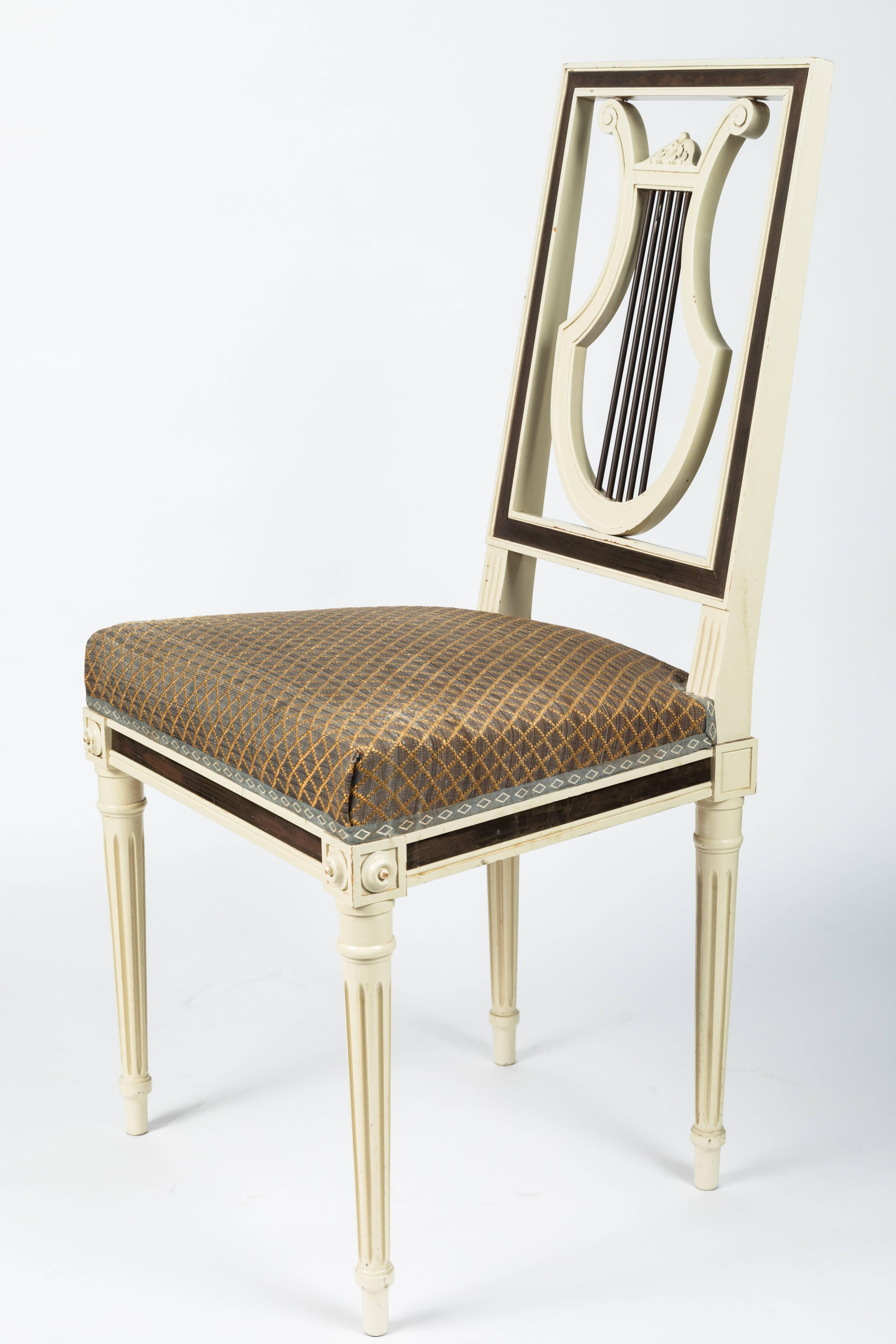 Set of four Louis XVI style lyre back dining chairs, created in the 1960s by Maison Jansen. Cream lacquer with brass inlay. Re-upholstered in Clarence House horsehair.