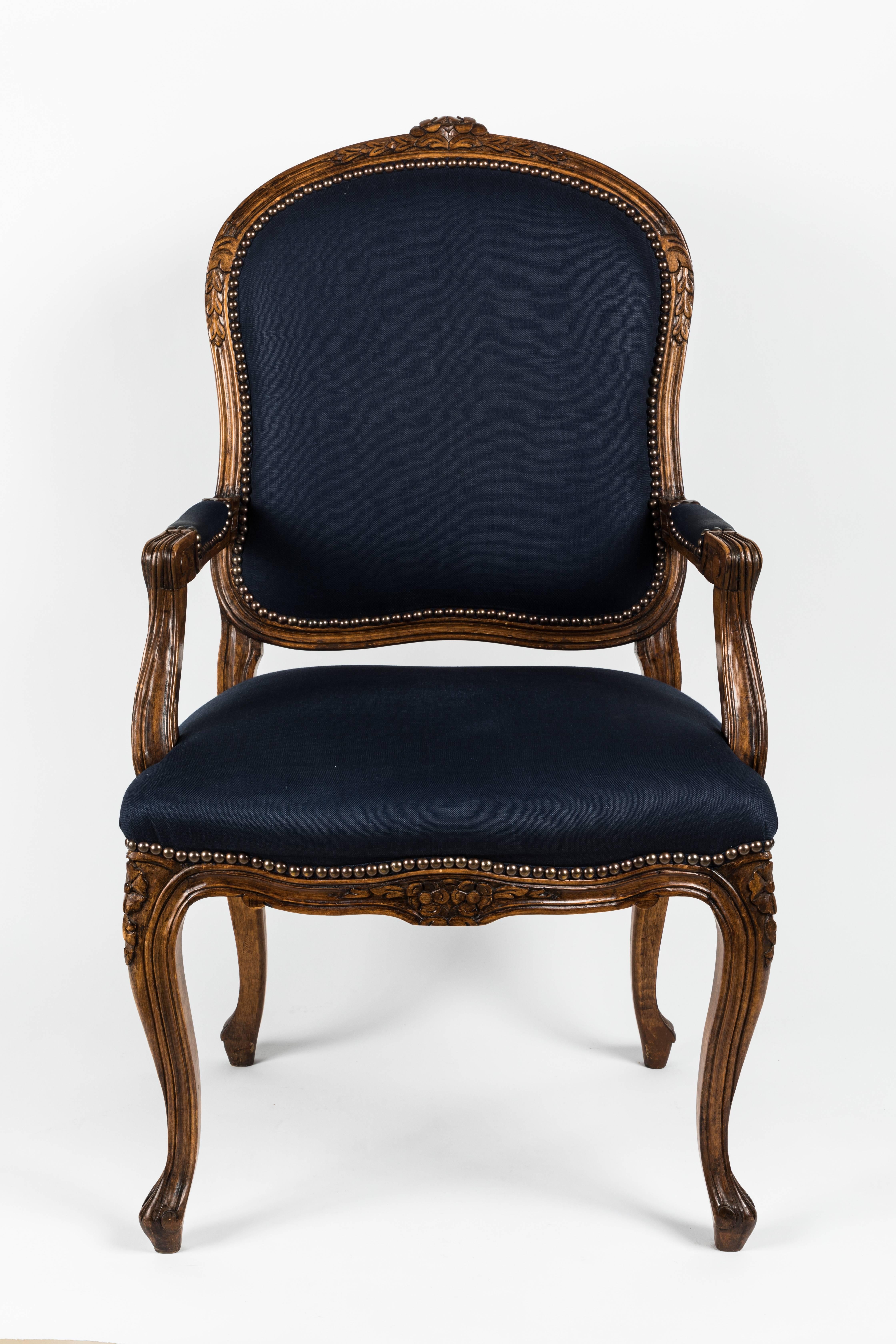 Pair of Louis XV Fauteuil armchairs. Carved fruitwood frame has been refinished. Newly upholstered in navy blue linen with bronze nailheads.