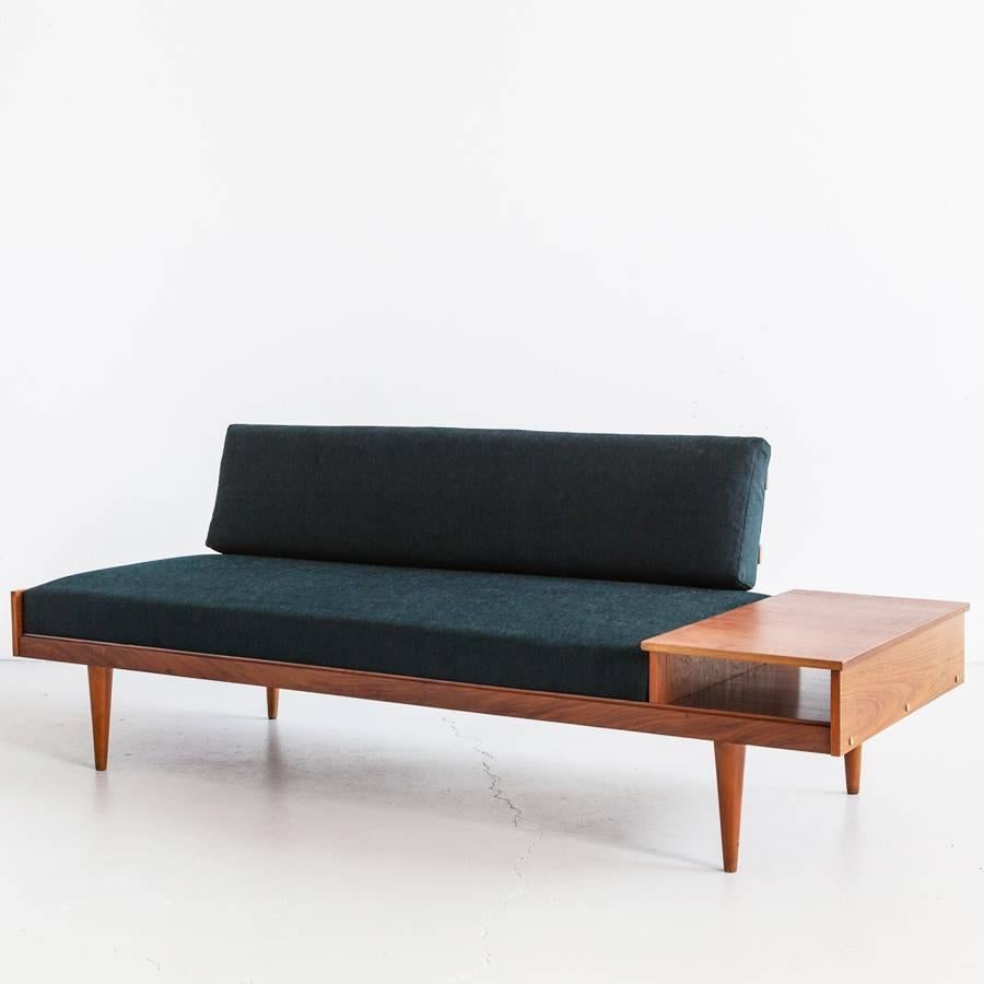 Small sofa in wood and fabric with side container.
 