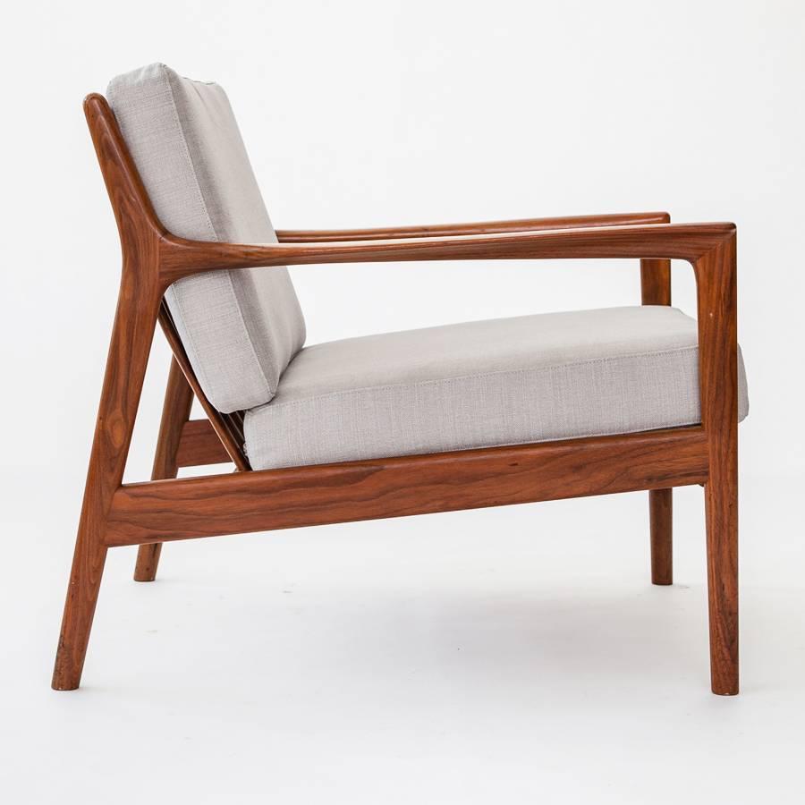 Pair of “USA -75” lounge chairs, in walnut with loose cushions in fabric.