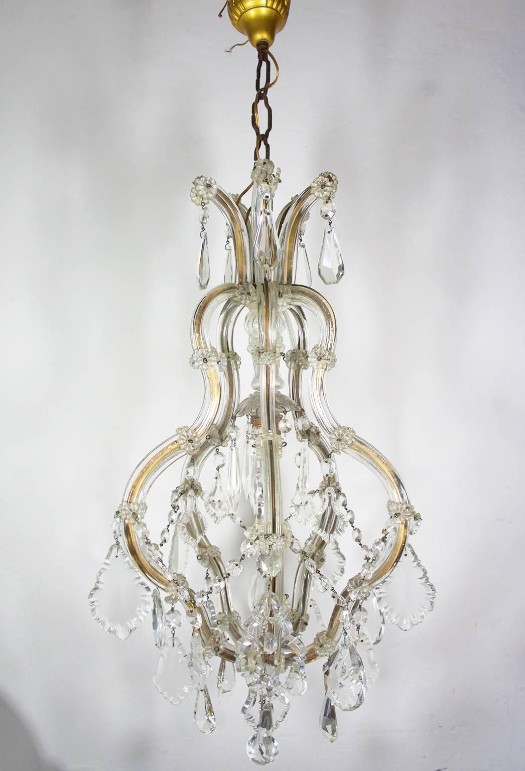 1940s typical Italian Murano glass and crystal drop Maria Theresa cage chandelier on a brass frame. 
Overall excellent condition (please see all photos), one of the crystal drops is missing and one replaced with a detail of different shape. 
One