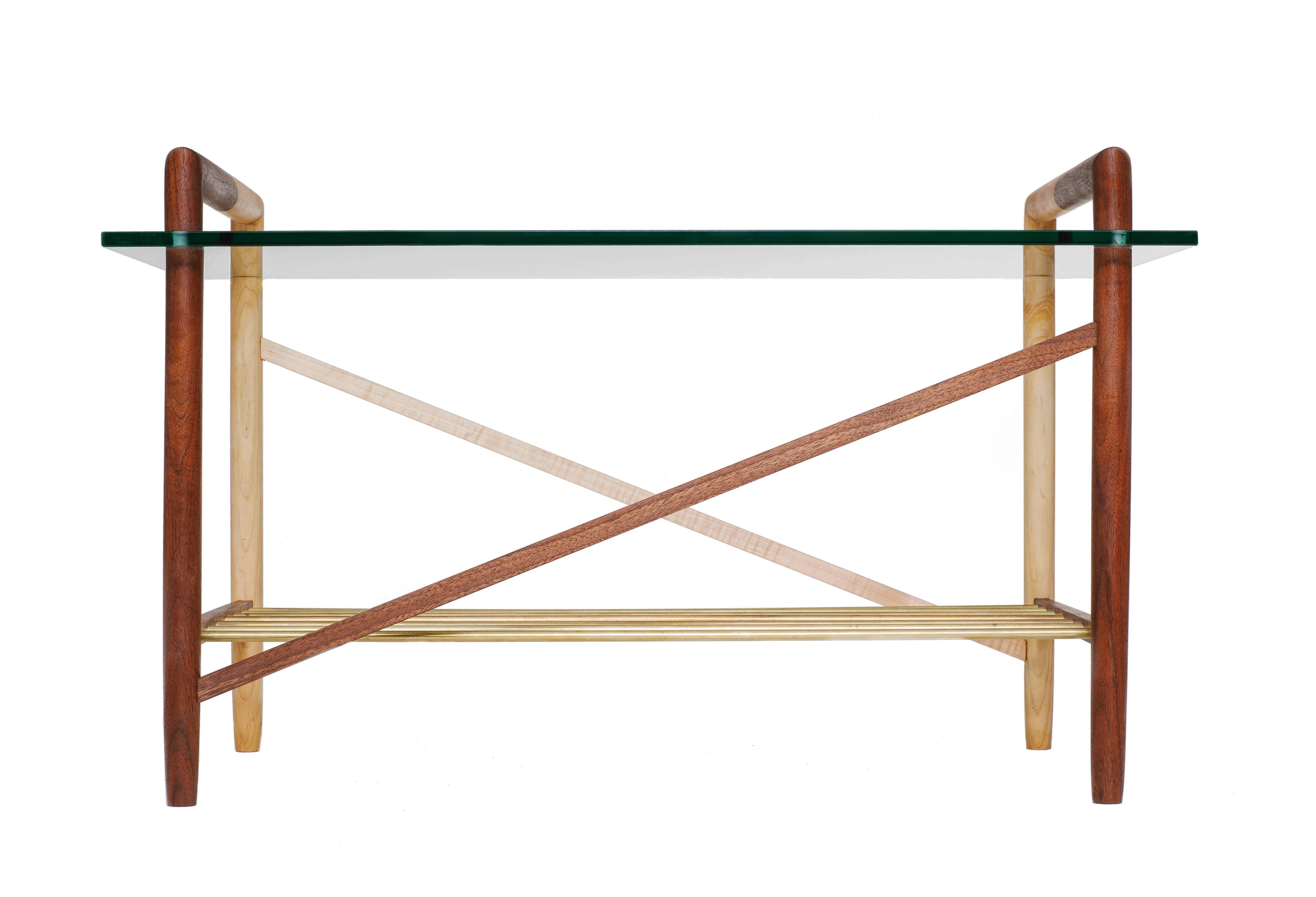 Switchback intersecting wood species. Fine metal shelving rods and polished glass top. Made in Los Angeles, California.

Shown in walnut, maple and brass with clear tempered glass. 

Please inquire for custom wood, metal and glass options.