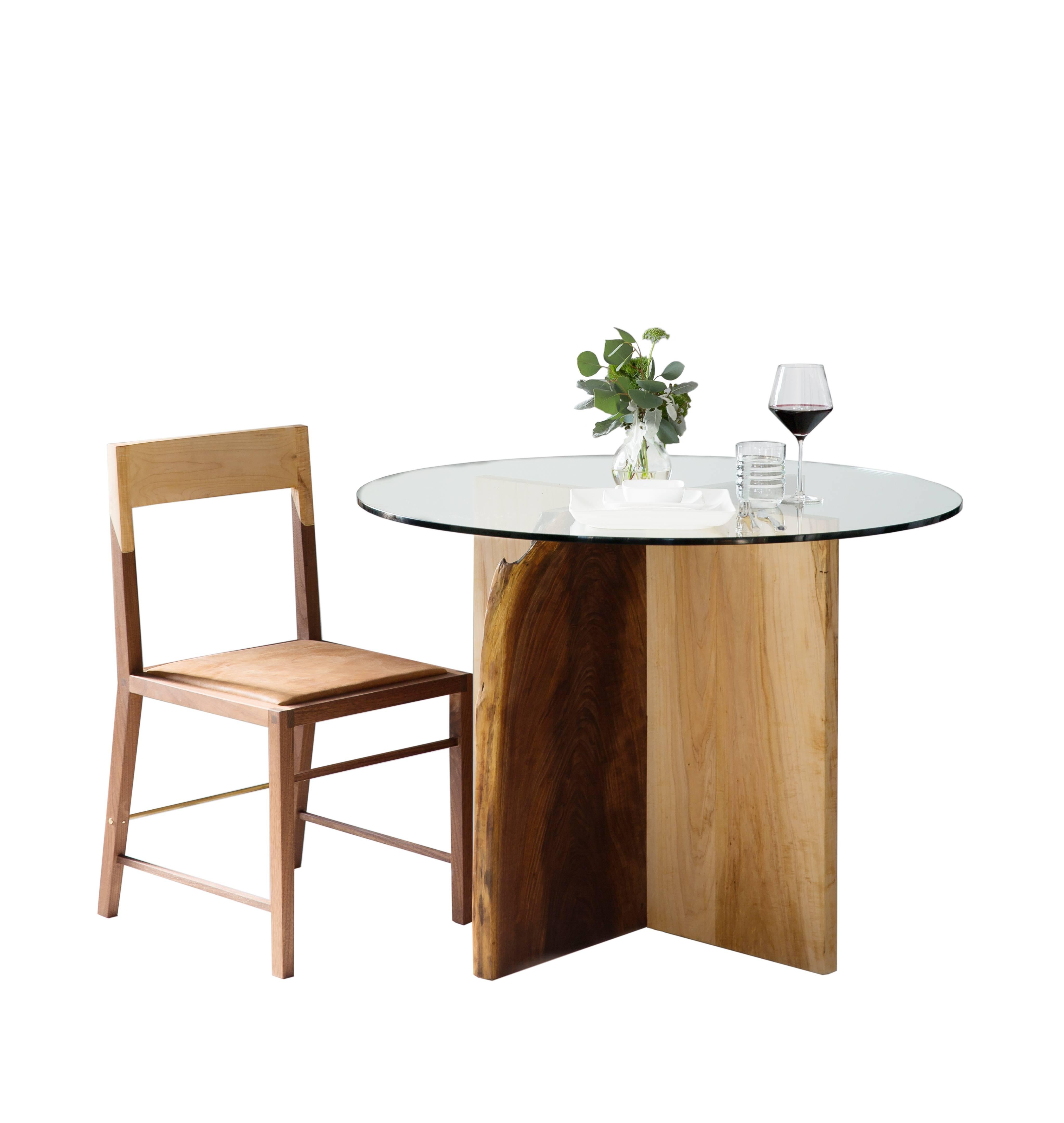 Natural edge intersected wood slab dining table base. Fine metal Dutchman joint. Polished glass top. Handmade in Los Angeles, California.

Here shown in walnut and maple with a brass Dutchman Joint, and a clear tempered glass top.

Wood base is